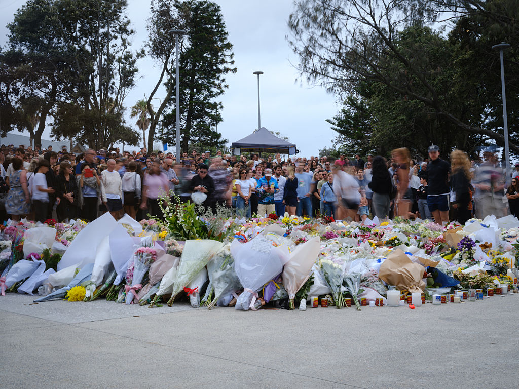 Leute legen Blumen an einer Gedenkstätte am Bondi Pavilion ab, nachdem es gestern, am 15. Dezember 2025, in Sydney, am Bondi Beach einen Amoklauf gegeben hat. | Quelle: Getty Images
