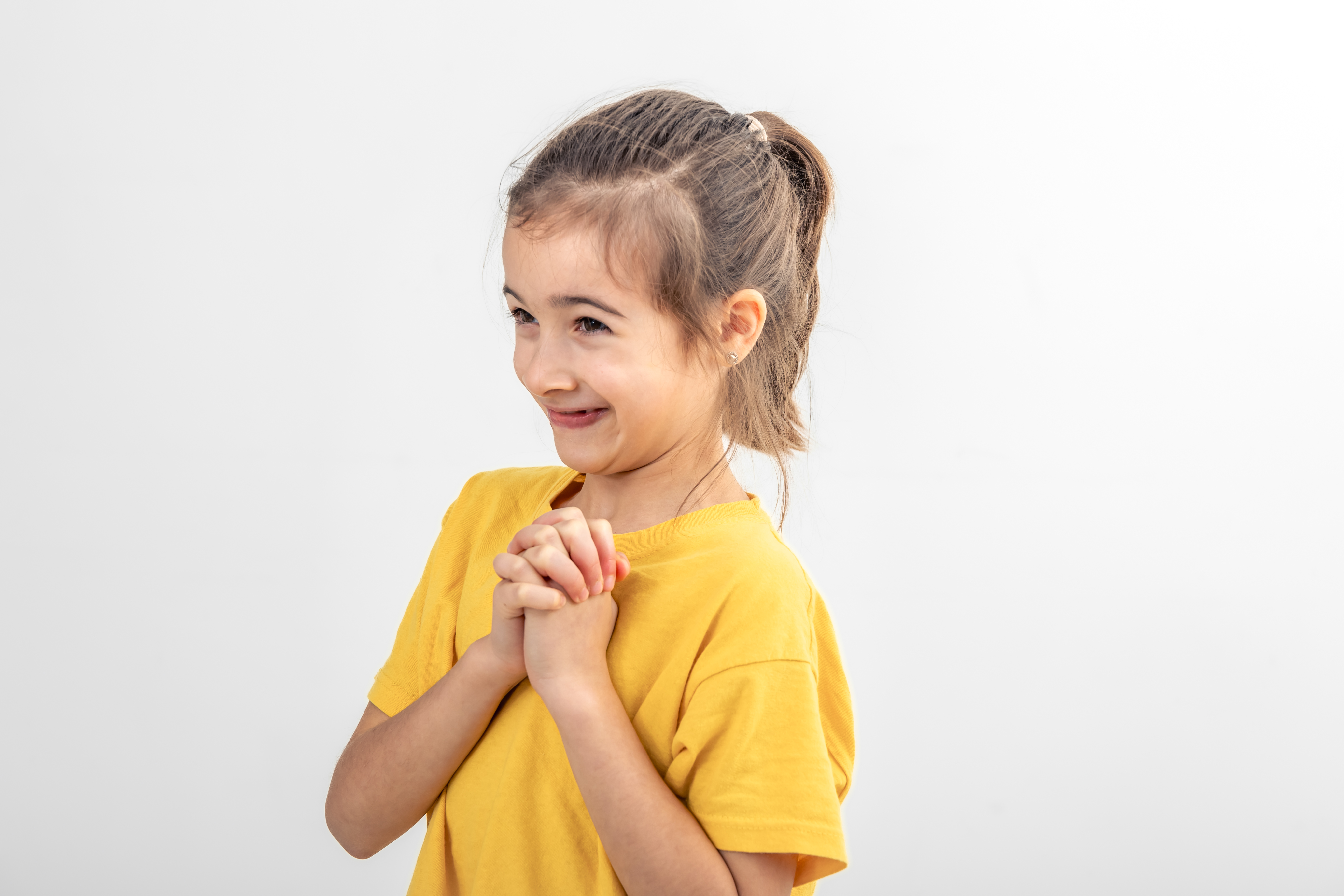 Ein glückliches Mädchen, das seine Hände umklammert | Quelle: Freepik