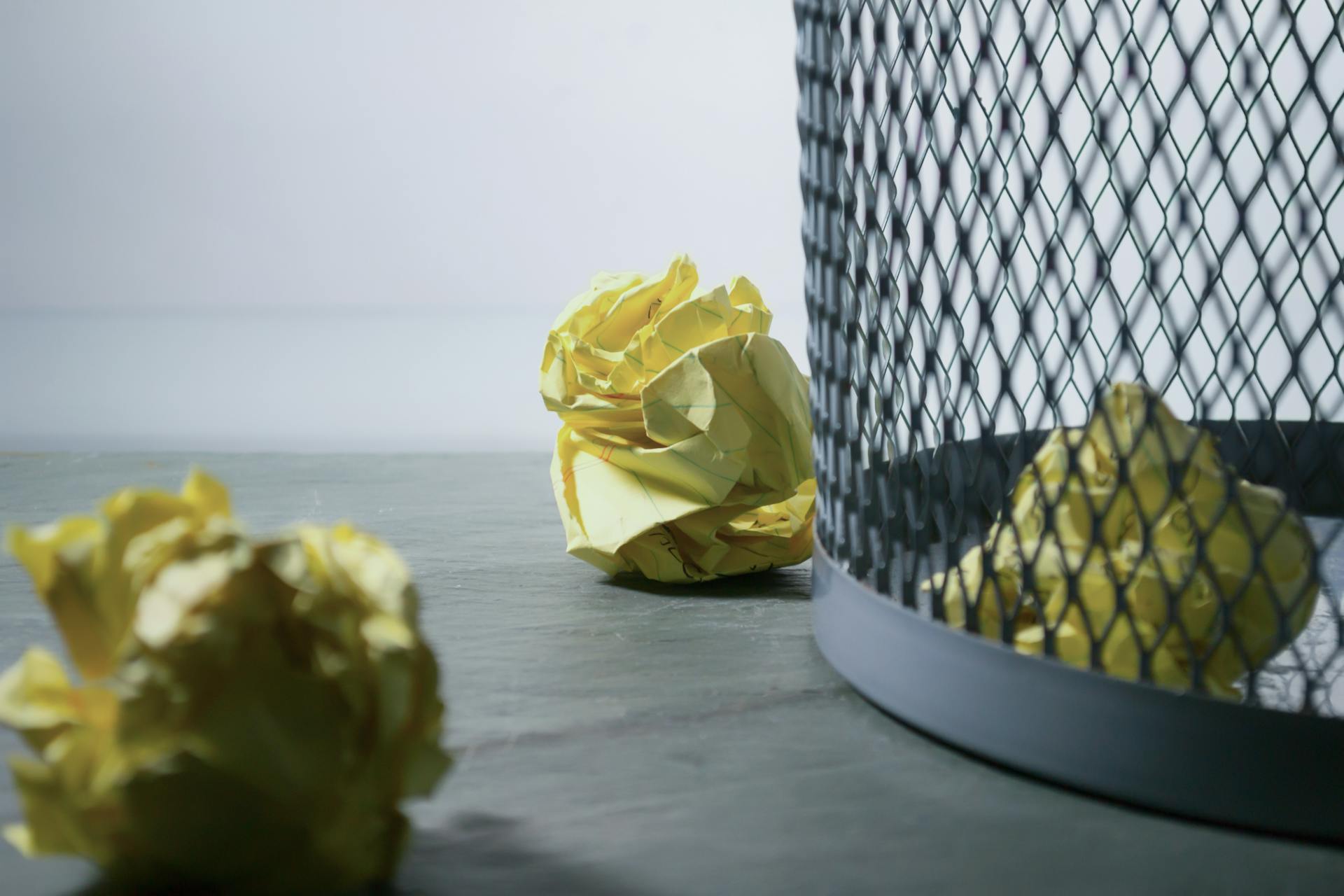 Zerknülltes Papier neben Mülleimer | Quelle: Pexels