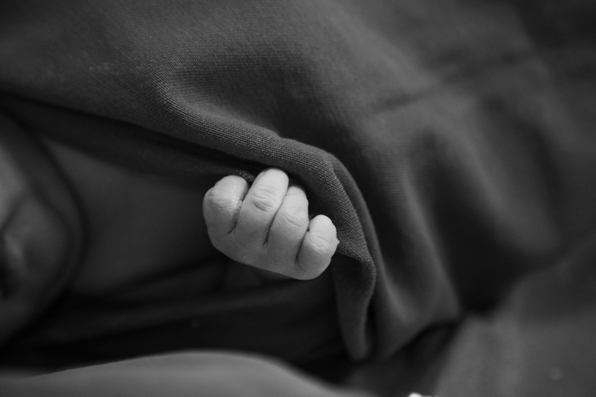 Die kleine Hand eines Babys, die sich an einer Decke festhält | Quelle: Pexels