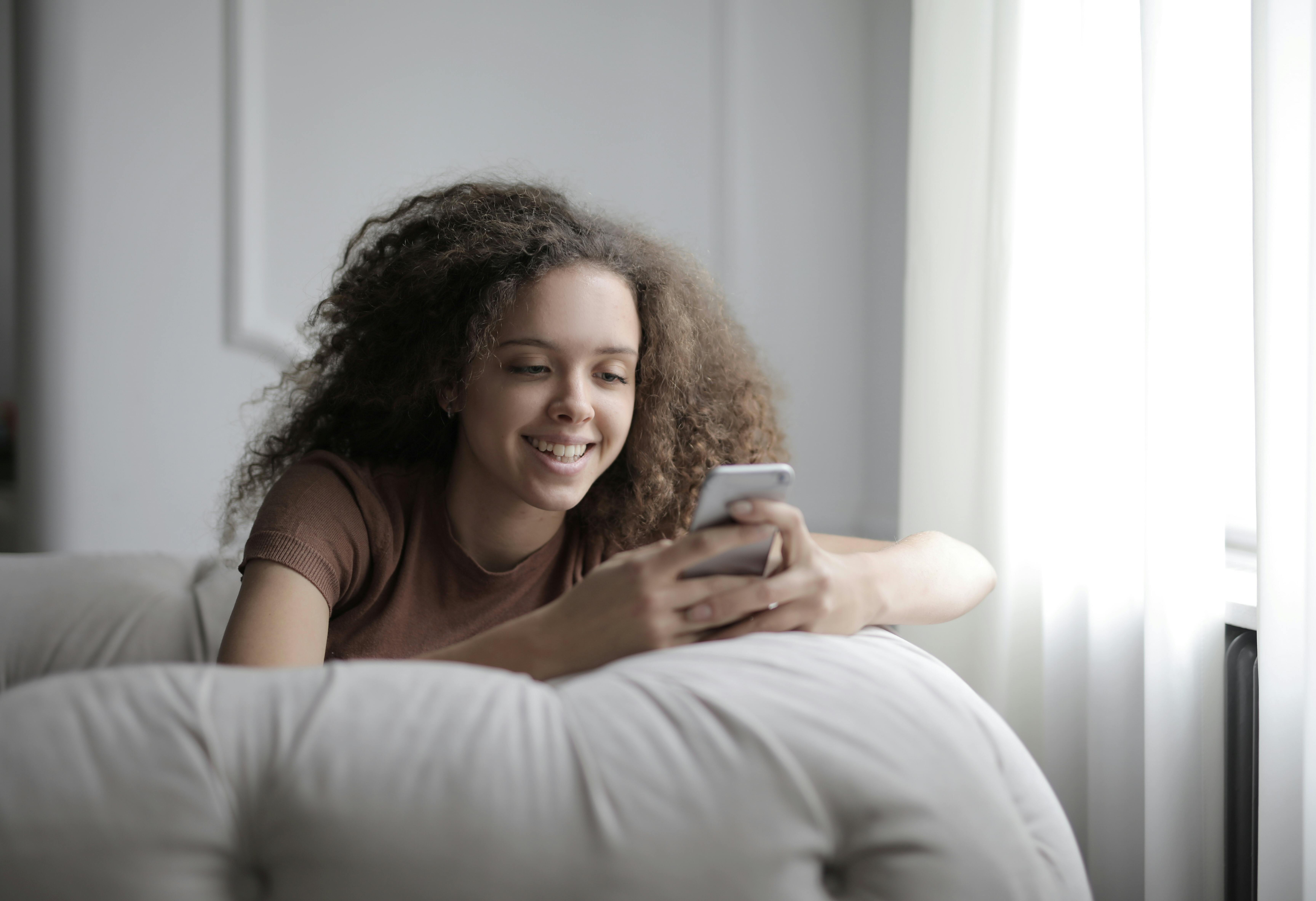 Ein glückliches Mädchen an ihrem Telefon | Quelle: Pexels