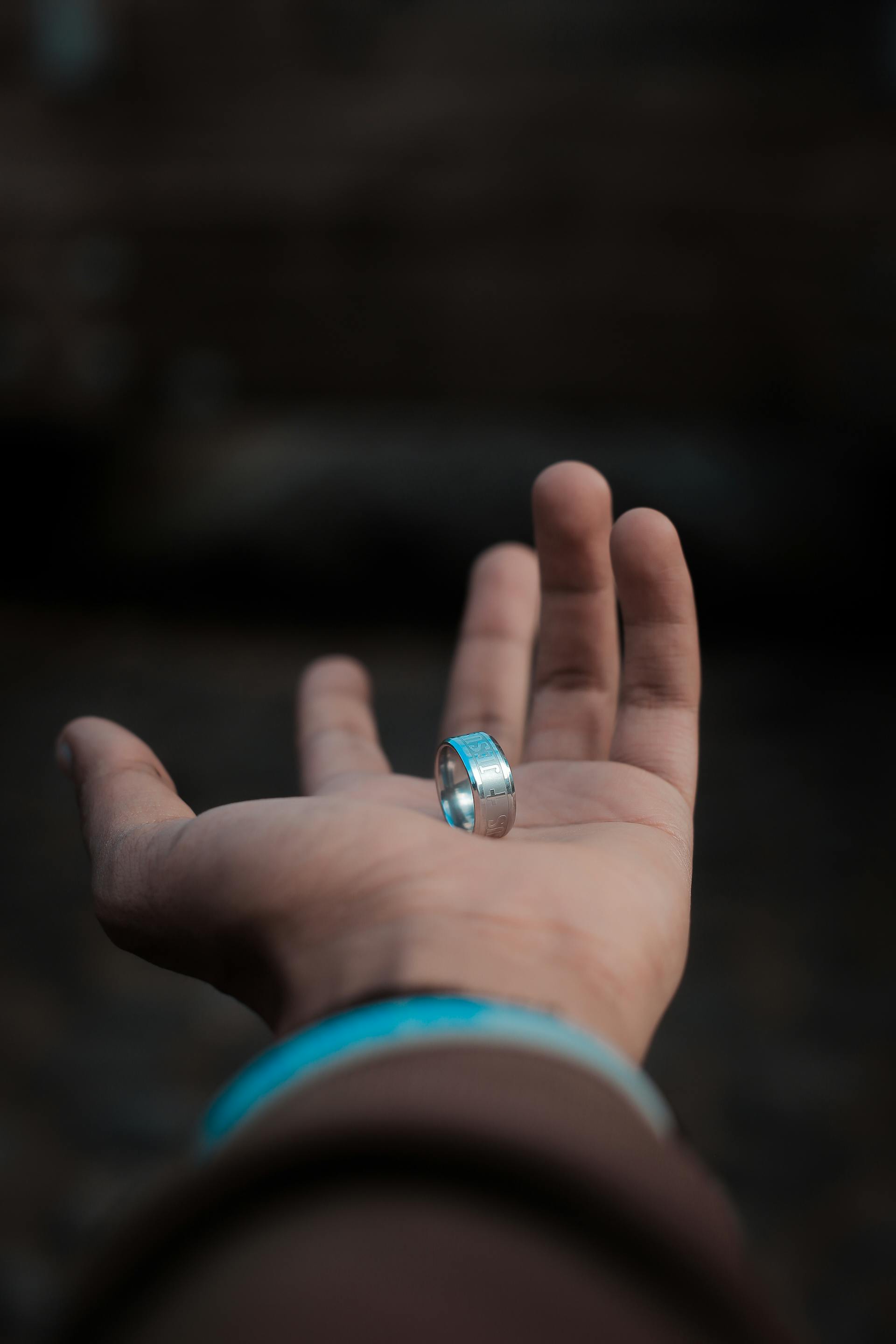 Ein Mann hält einen schlichten Ring in die Höhe | Quelle: Pexels