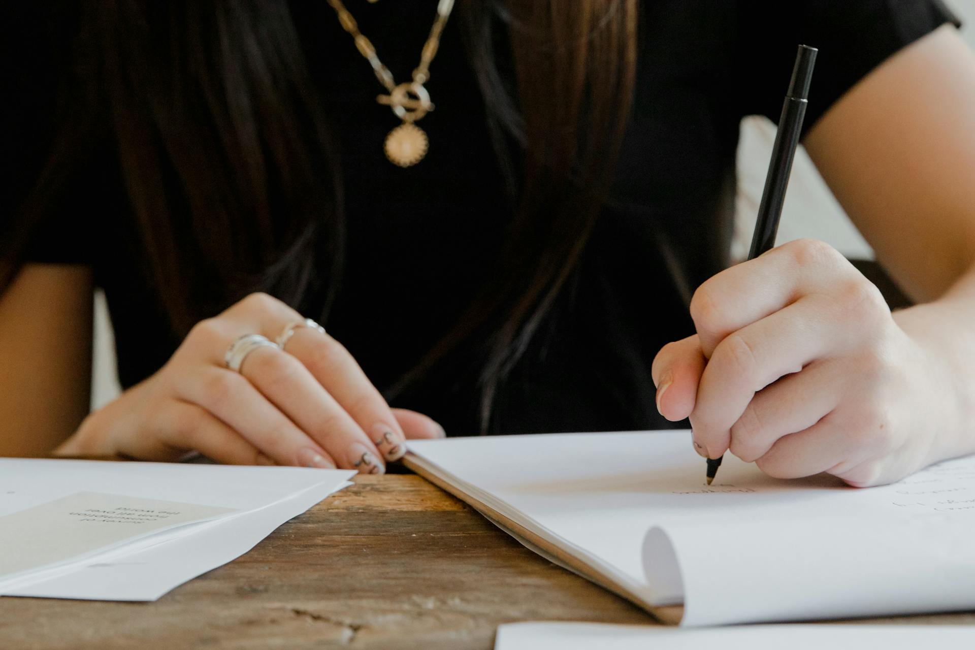 Eine Frau, die auf Papier schreibt | Quelle: Pexels