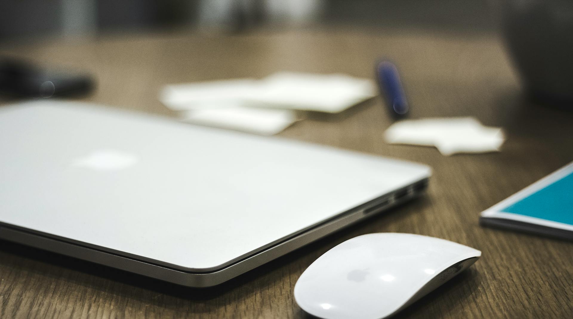 Ein Laptop und eine kabellose Maus auf dem Tisch | Quelle: Pexels
