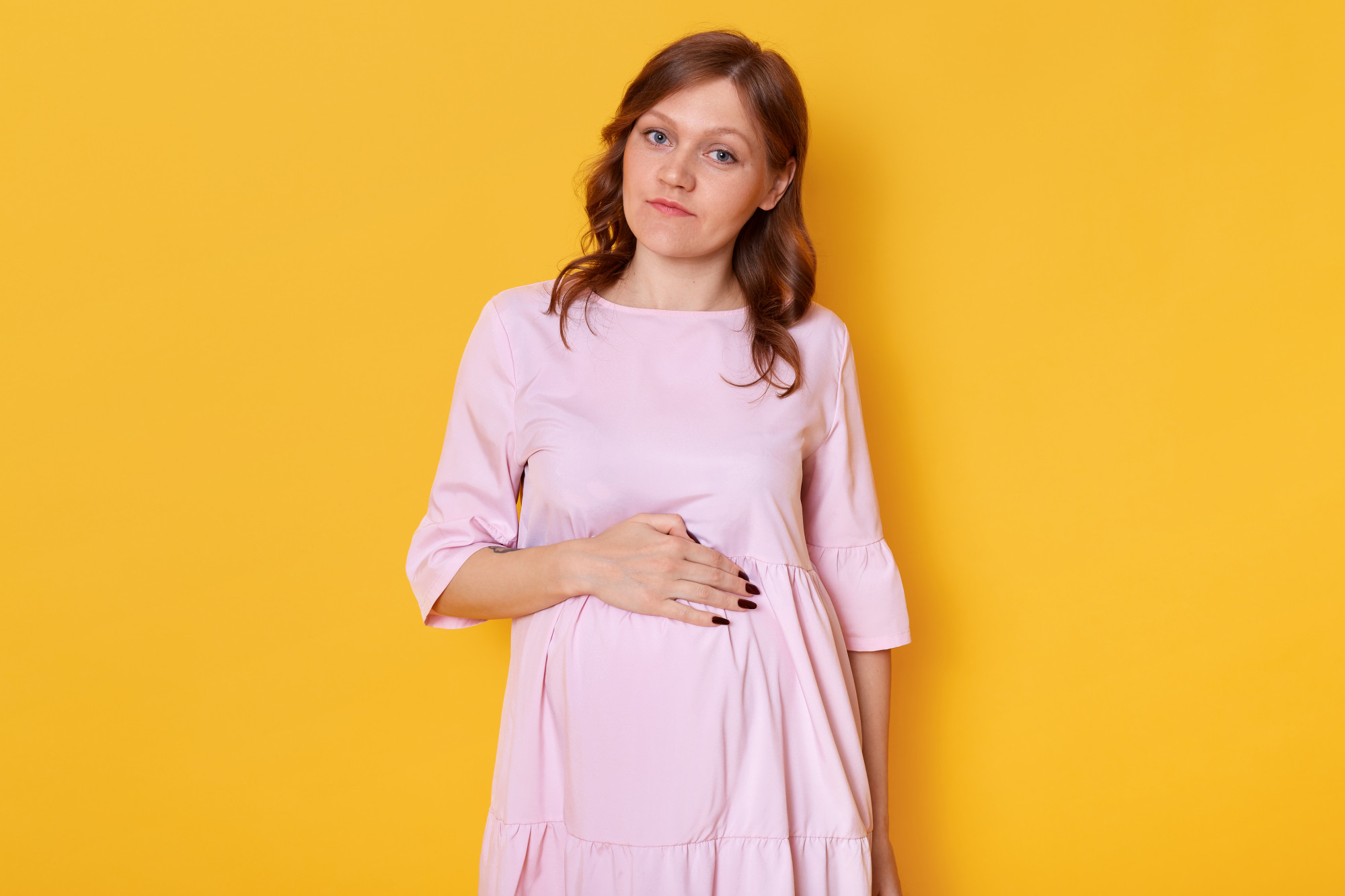 Eine schwangere Frau, die ihren Babybauch hält | Quelle: Freepik
