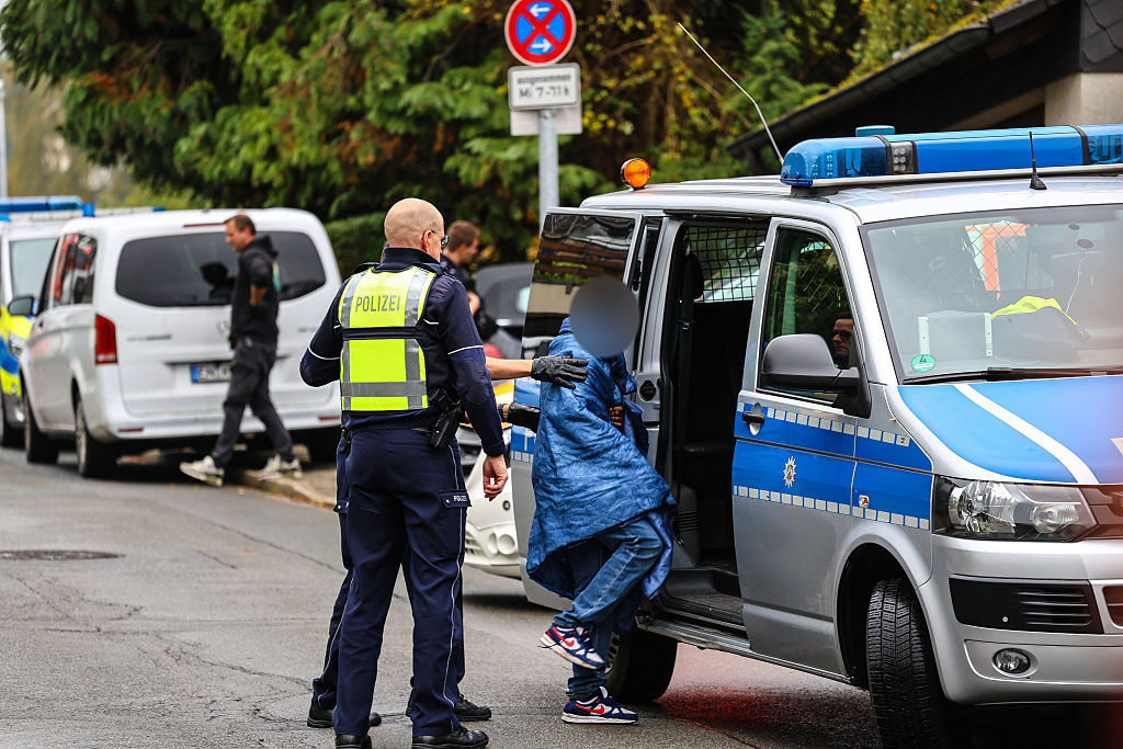 07. Oktober 2025, Nordrhein-Westfalen, Herdecke: Polizeibeamte bringen einen Jugendlichen in ein Polizeiauto. Die neu gewählte Bürgermeisterin von Herdecke, Iris Stalzer (SPD), ist schwer verletzt in ihrer Wohnung aufgefunden worden. Nach Angaben aus Sicherheitskreisen wurde sie mit mehreren Messerstichen verletzt | Quelle: Getty Images