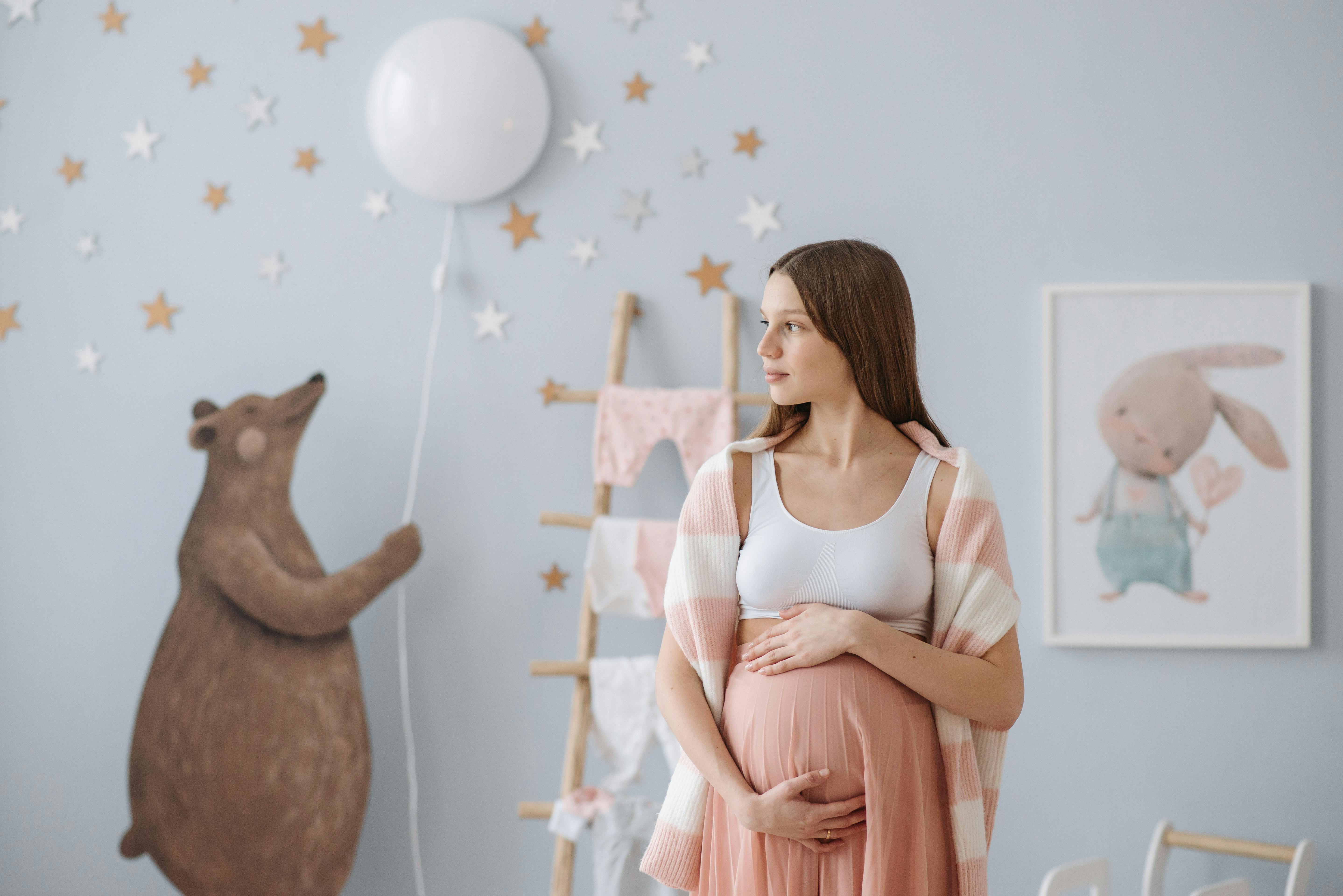 Eine schwangere Frau, die in einem Kinderzimmer steht | Quelle: Pexels