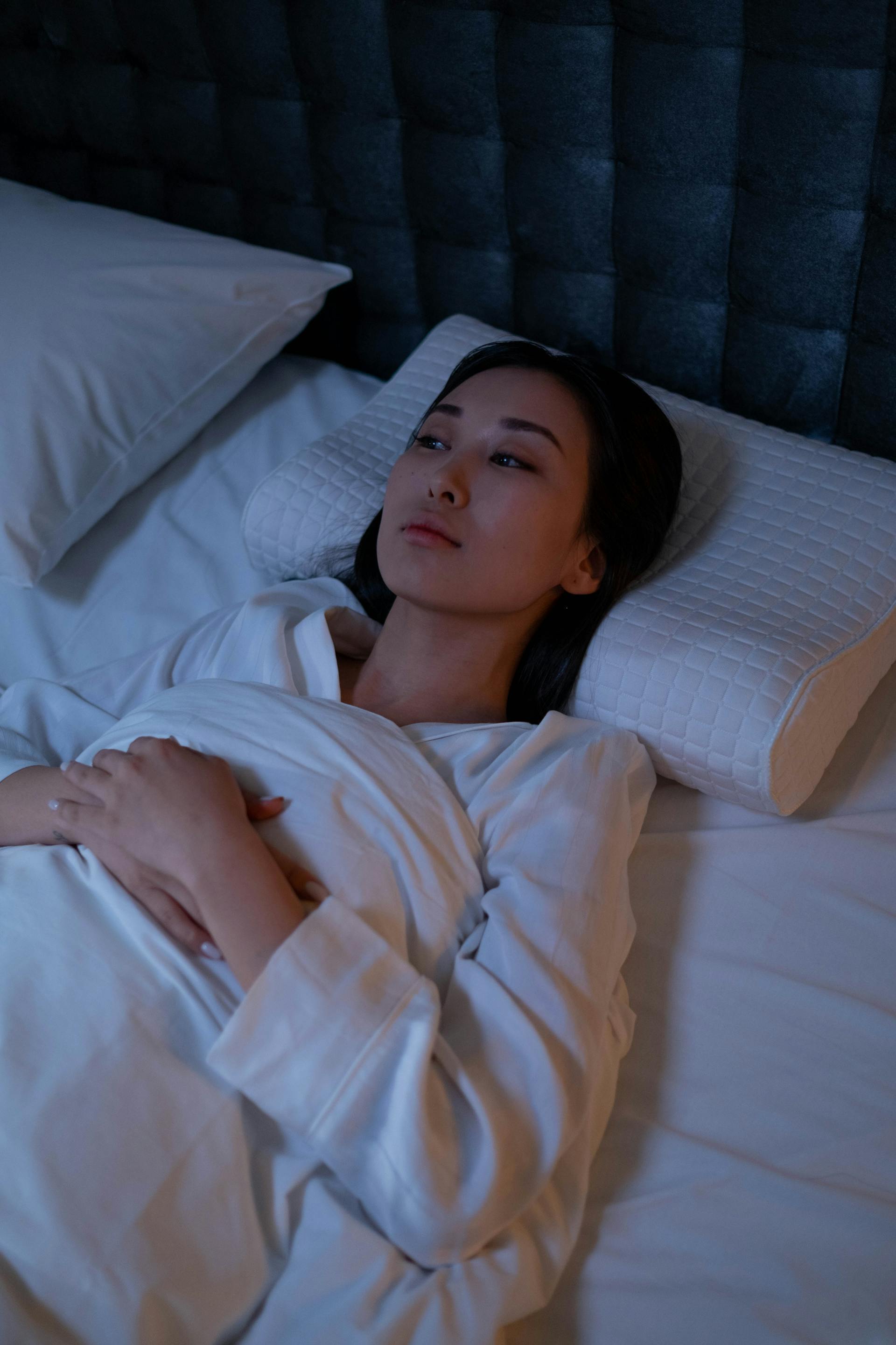 Eine Frau, die wach im Bett liegt | Quelle: Pexels