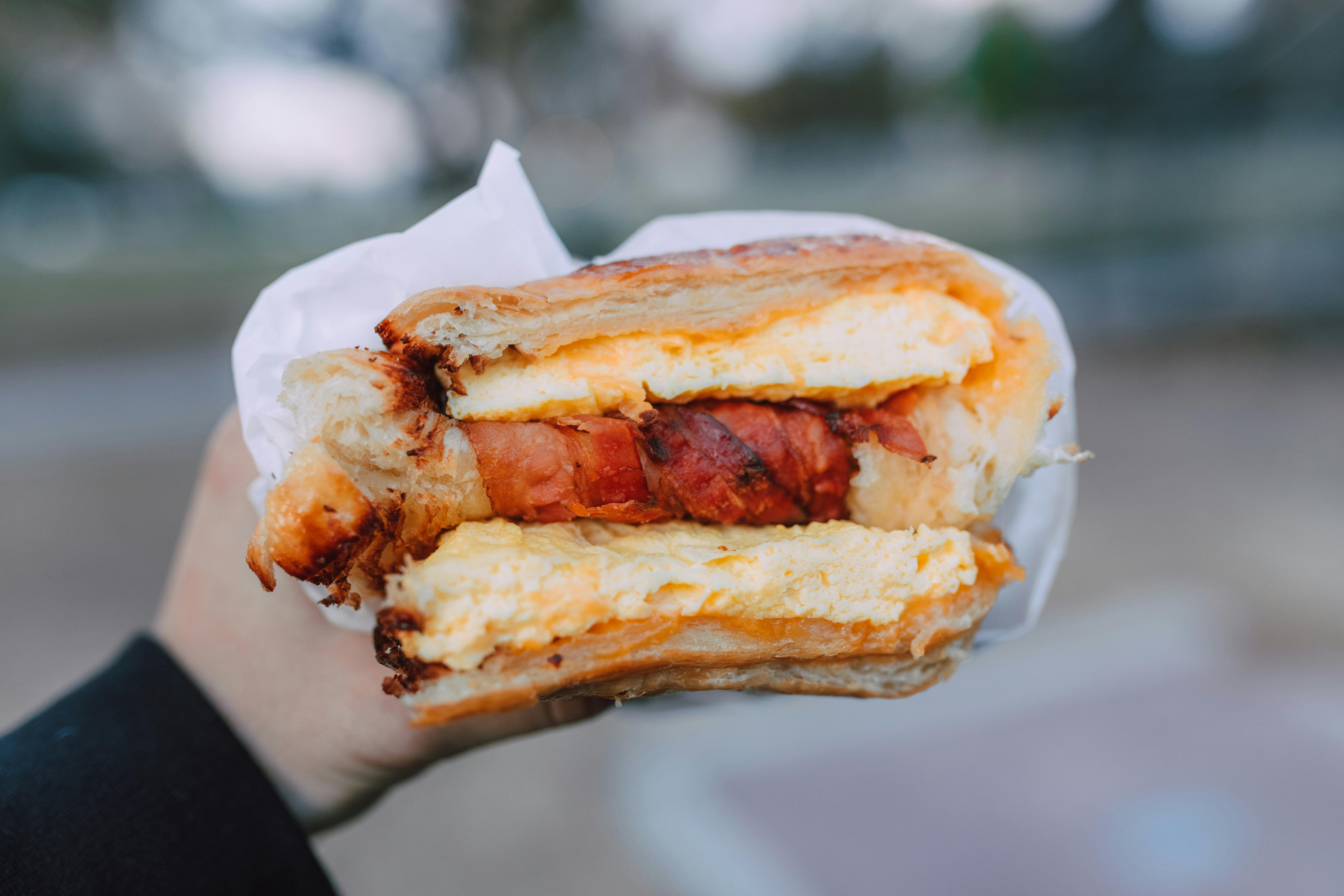 Eine Person mit einem Sandwich in der Hand | Quelle: Pexels