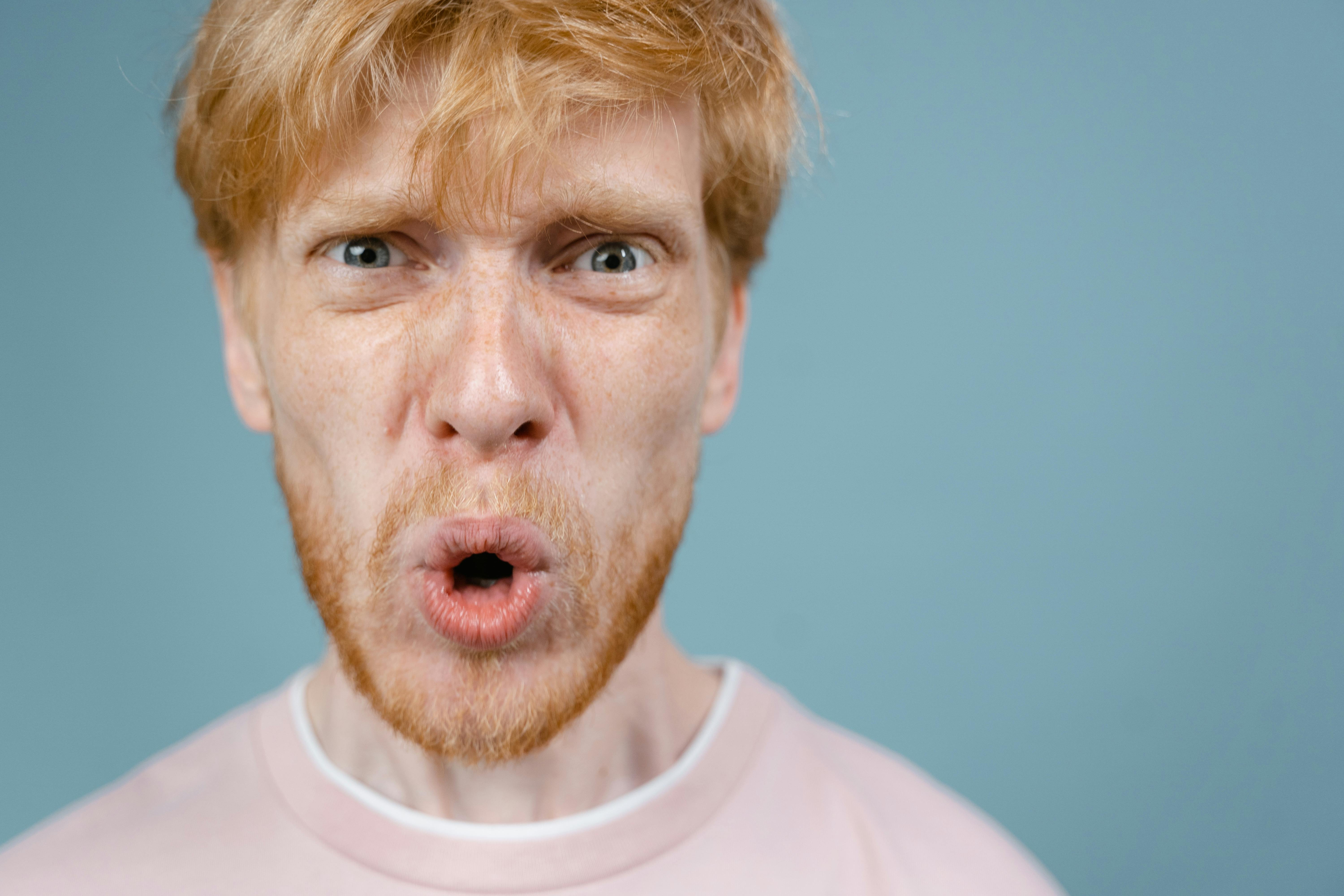 Ein wütender Mann in einem rosa T-Shirt | Quelle: Pexels
