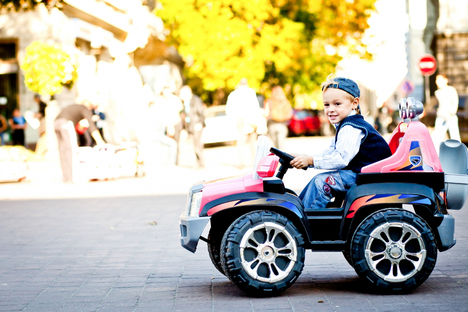 Ein glücklicher kleiner Junge fährt mit seinem Spielzeugauto | Quelle: Freepik