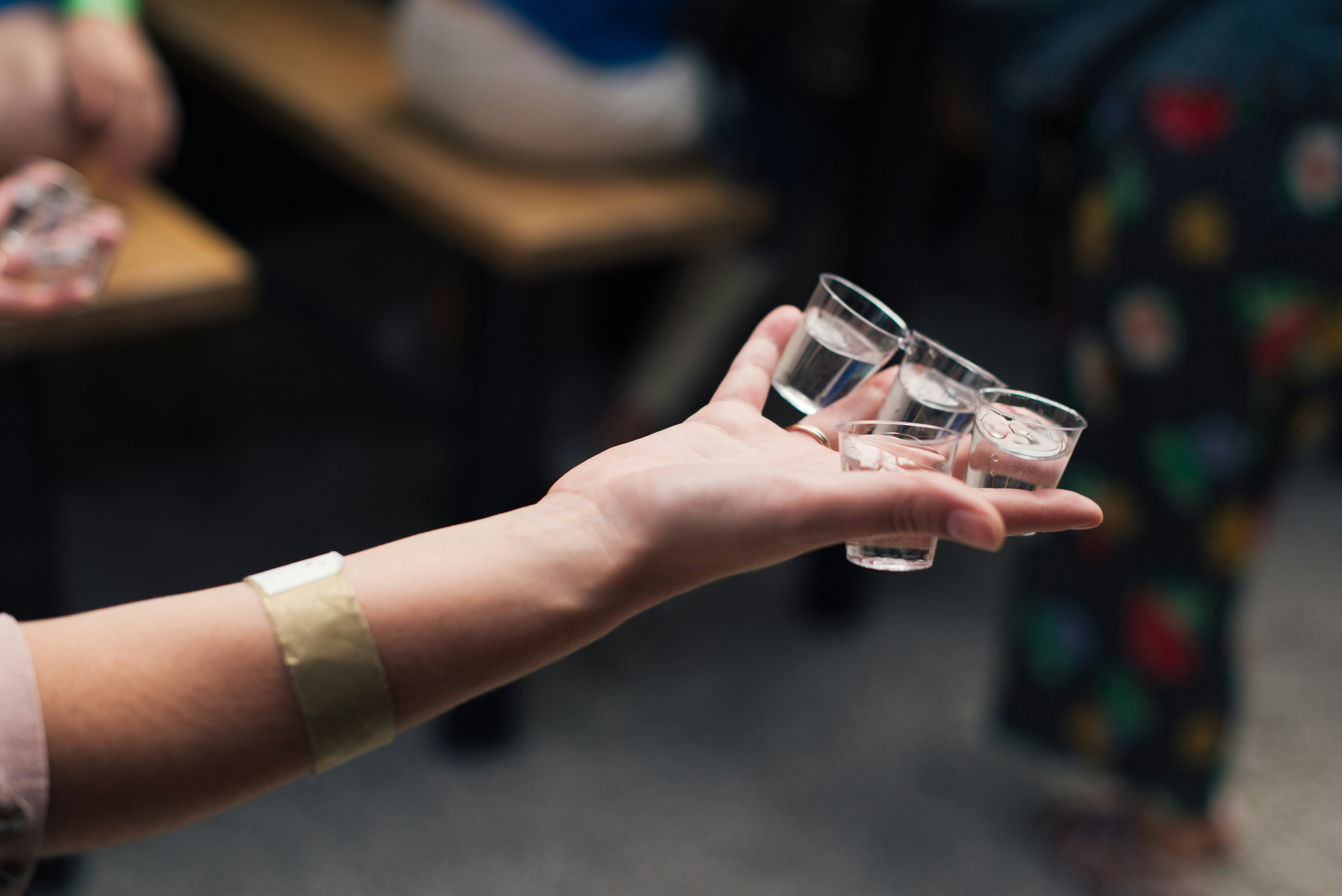 Eine Person mit Schnapsgläsern | Quelle: Unsplash