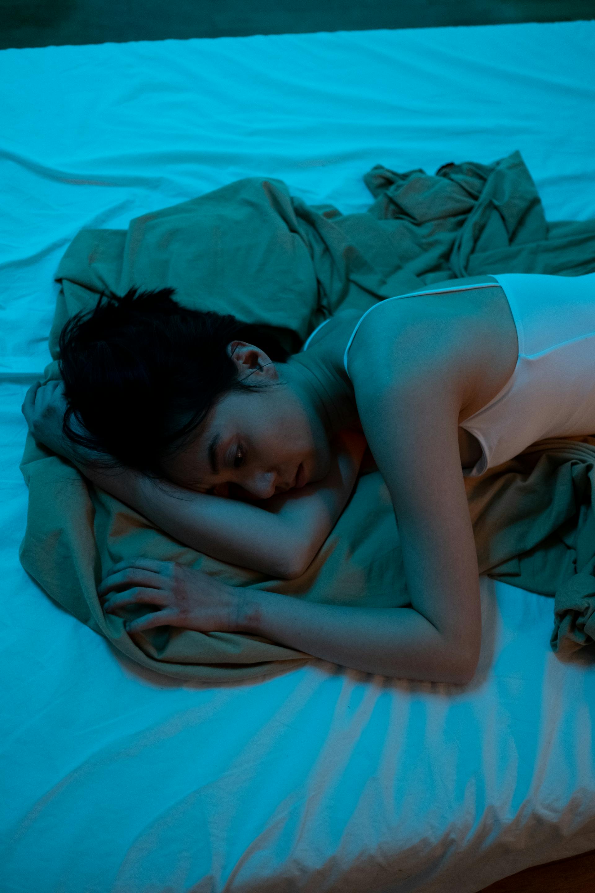 Eine traurige Frau, die auf einem Bett liegt | Quelle: Pexels