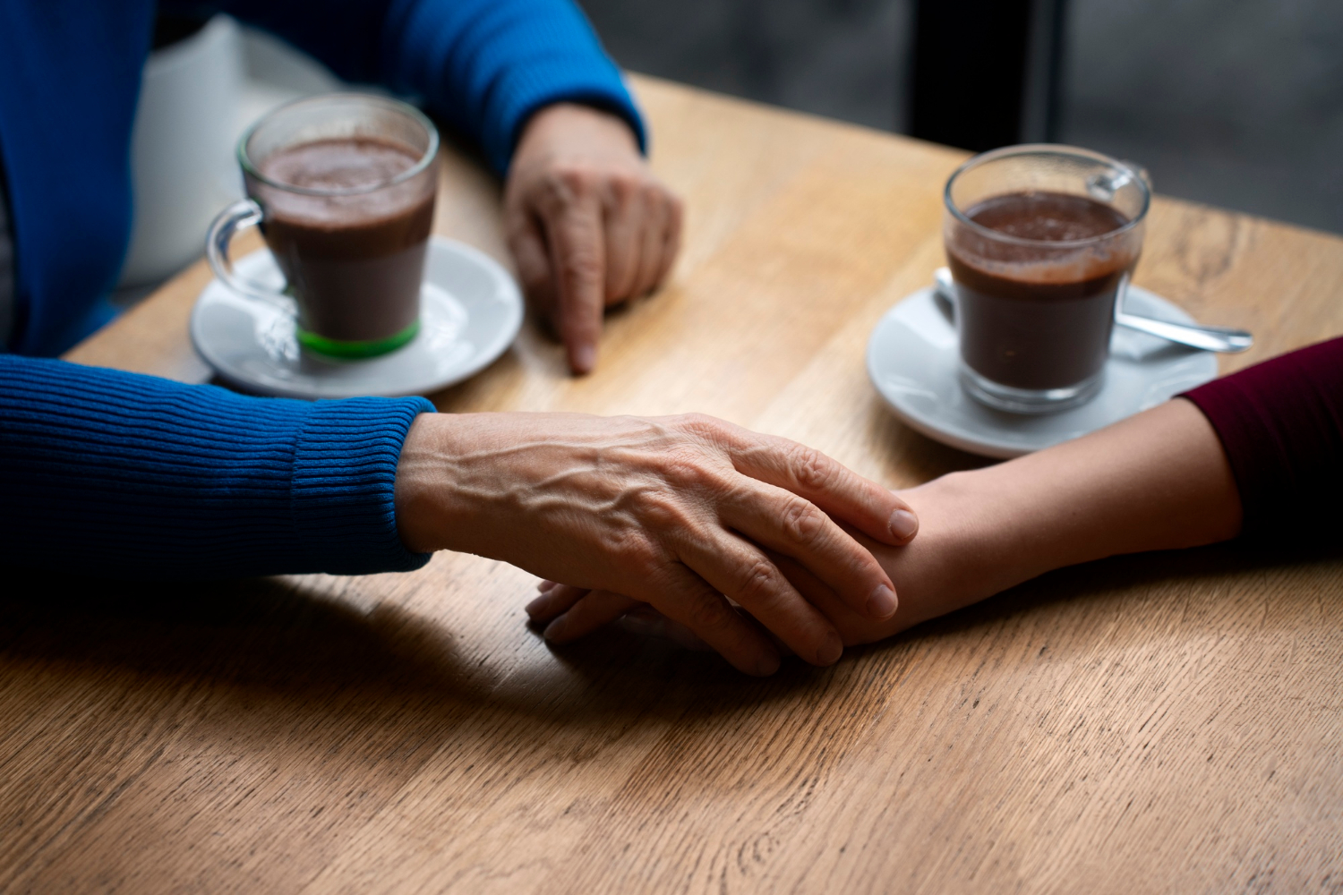Eine ältere Frau hält die Hand einer jungen Frau | Quelle: Freepik