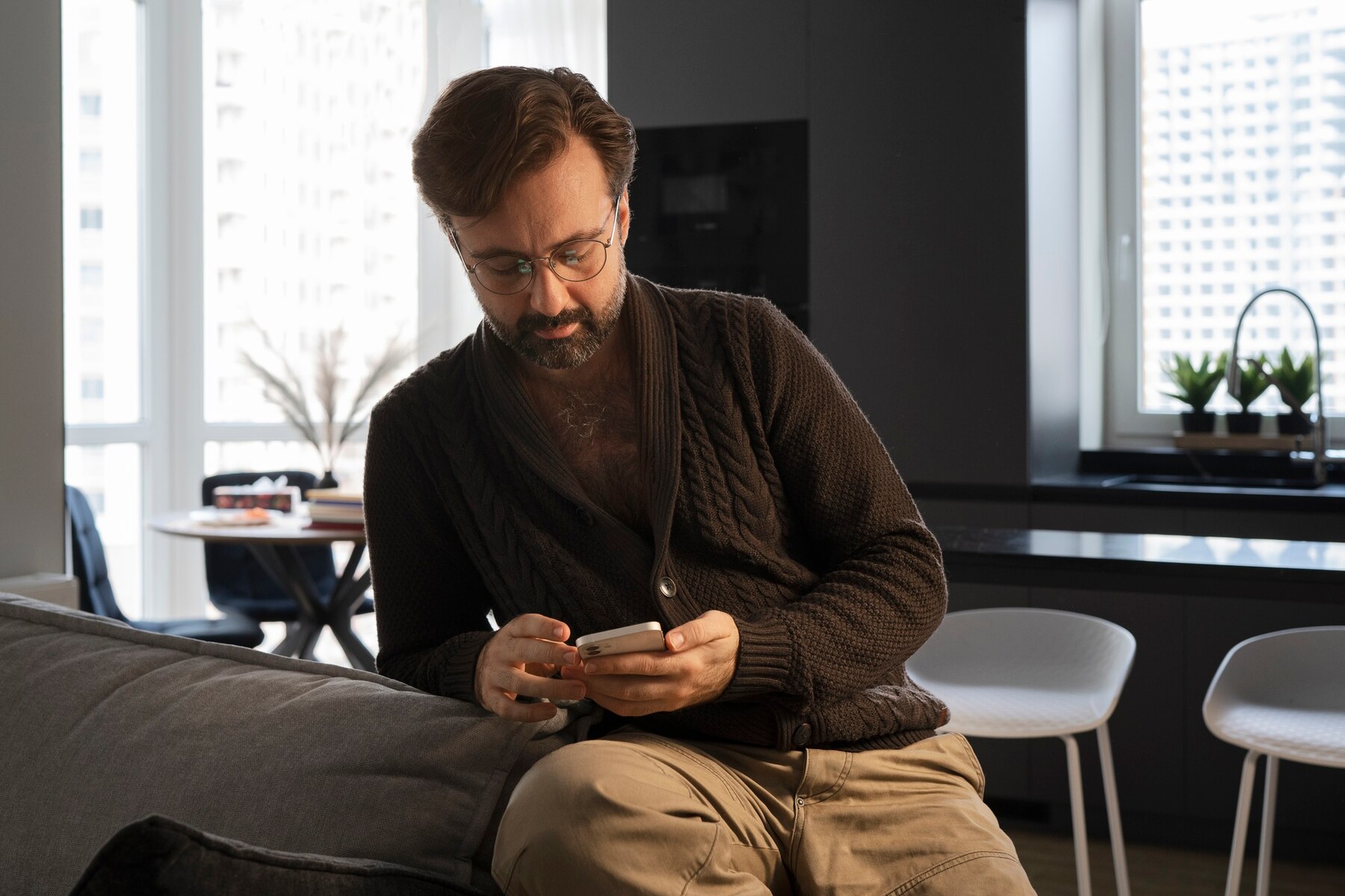 Ein Mann an seinem Telefon in seinem Wohnzimmer | Quelle: Freepik