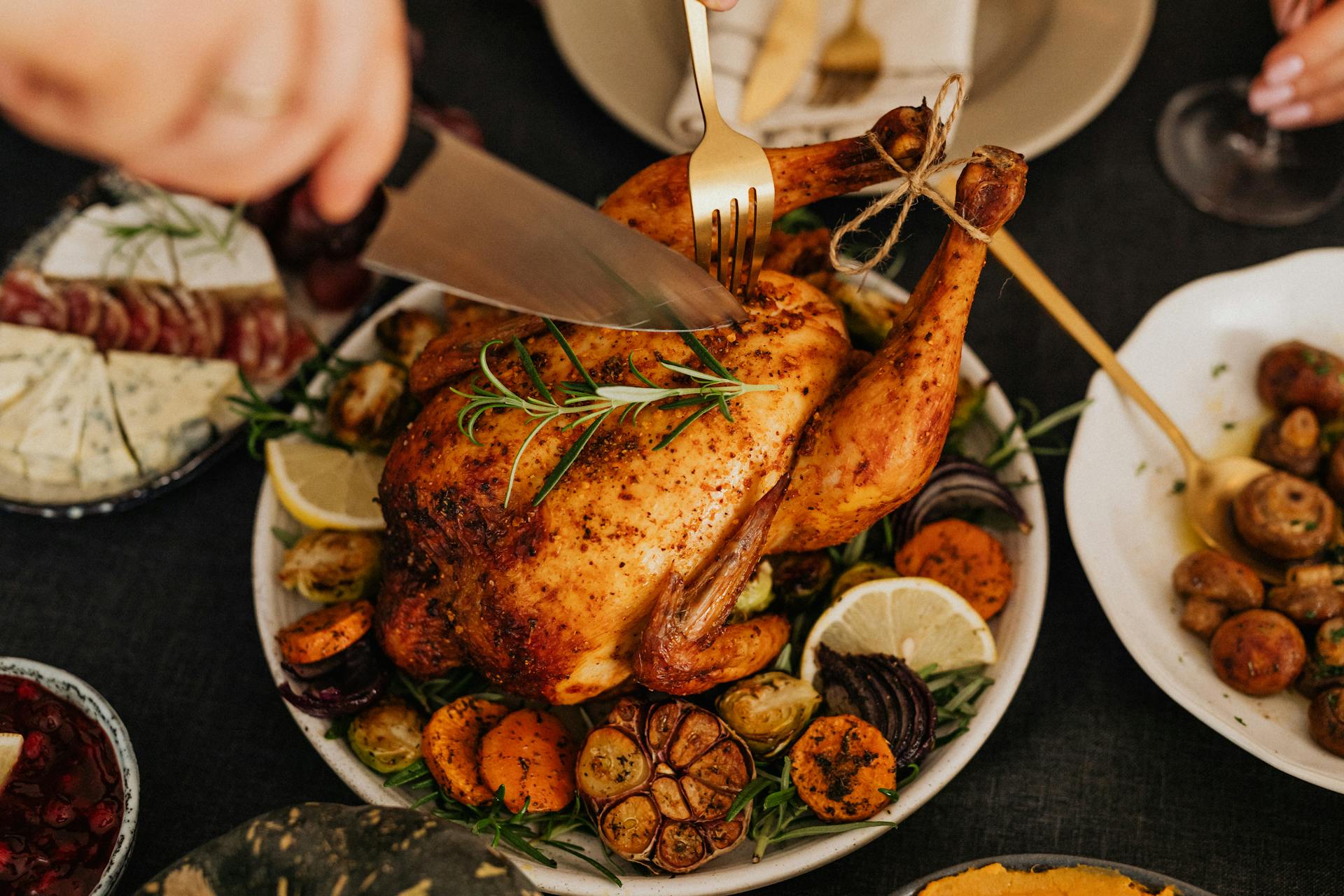 Eine Person, die gebratenes Huhn aufschneidet | Quelle: Pexels