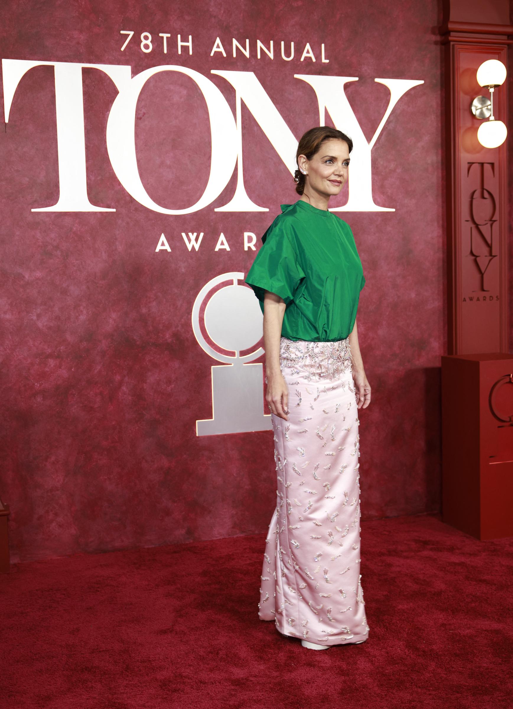 Mit einem Fuß leicht nach vorne und einer ruhigen Körperhaltung beherrscht Katie Holmes den roten Teppich in ihrem grün-rosa Ensemble. Das Foto fängt sowohl Eleganz als auch Kühnheit ein und spiegelt die Reaktionen wider, die ihr Look in den sozialen Medien hervorrief.