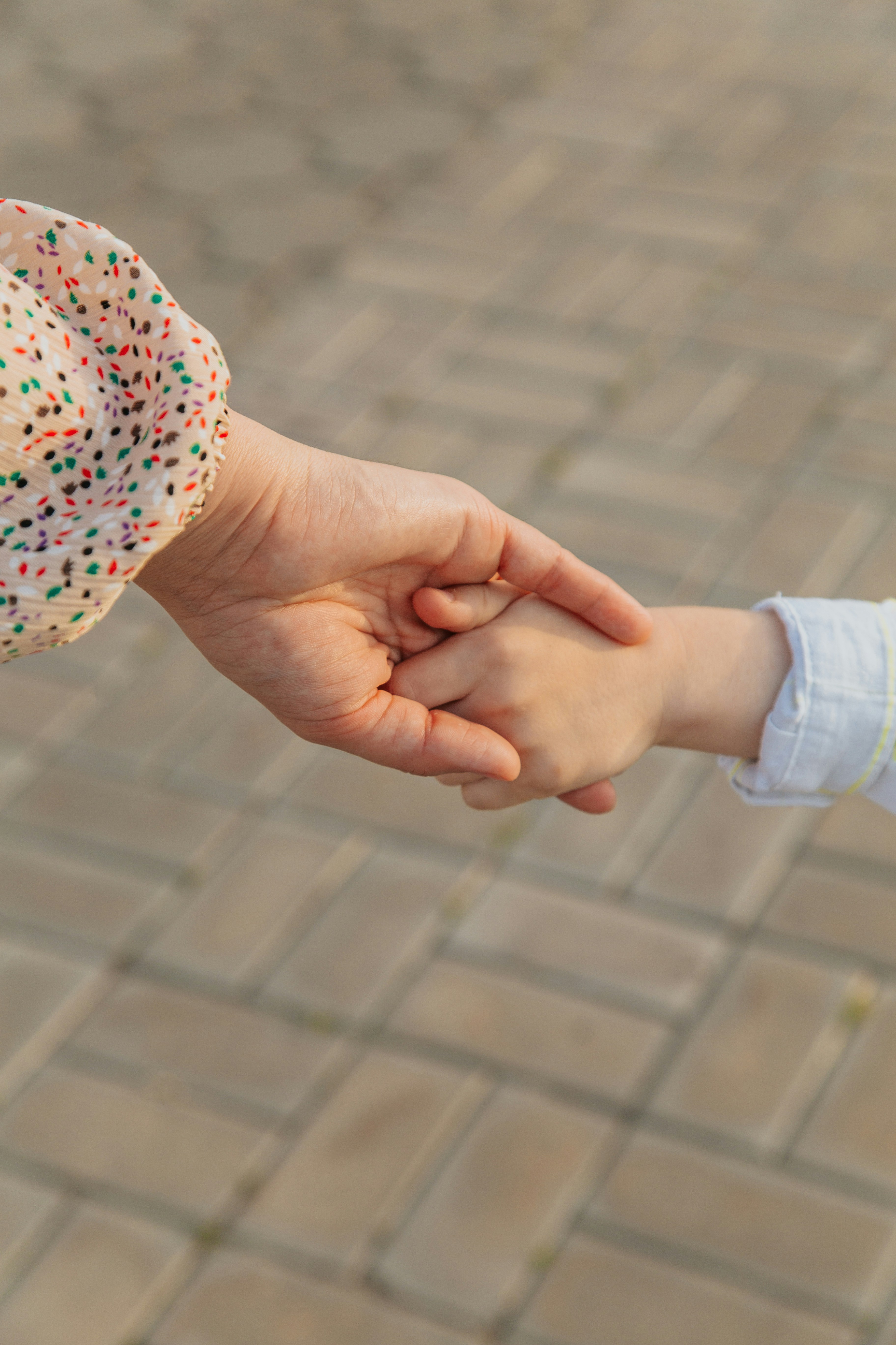 Eine Mutter und ihr Kind halten sich an den Händen | Quelle: Unsplash
