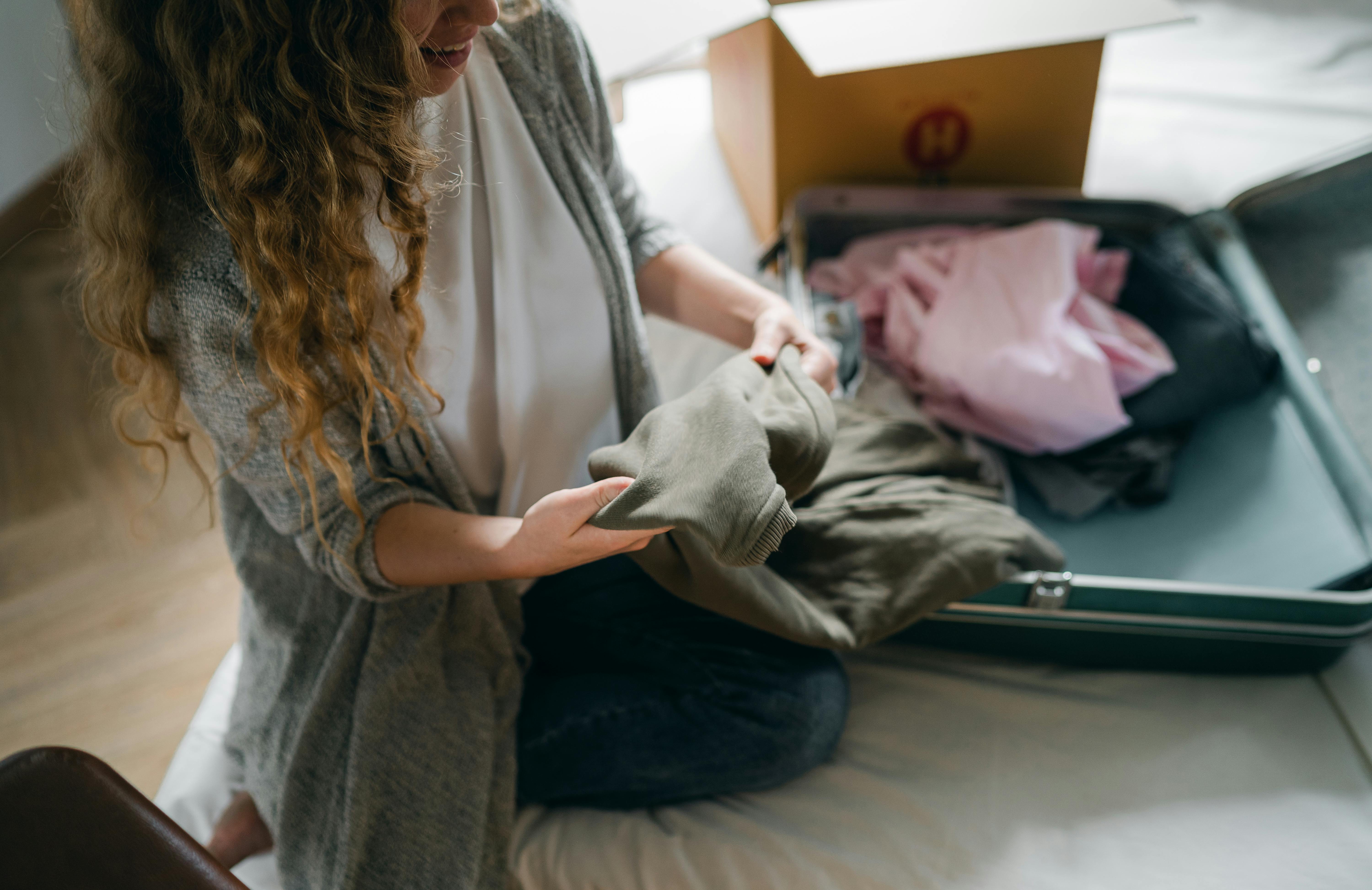Eine Frau packt ihre Kleidung in eine Tasche | Quelle: Pexels