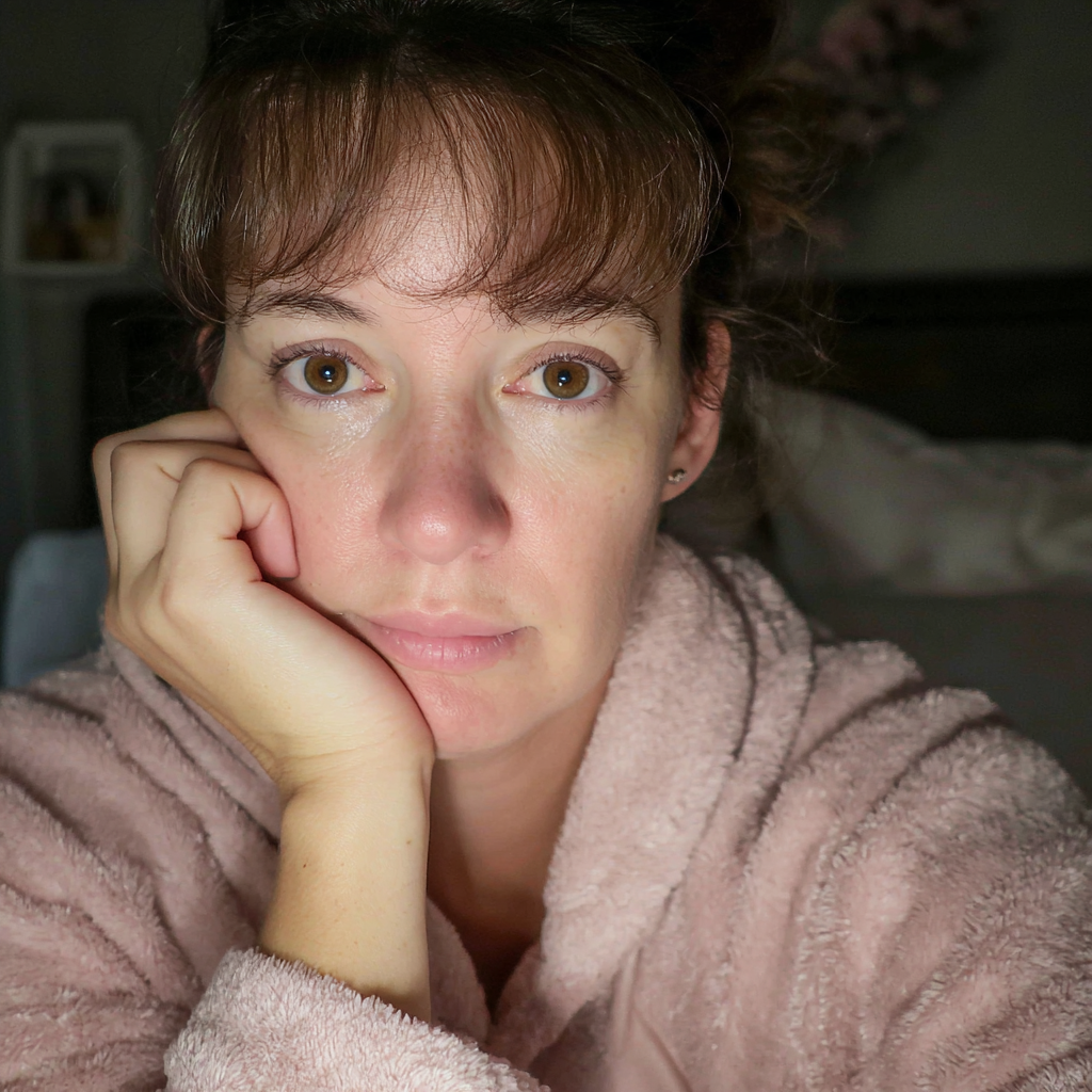 Eine Nahaufnahme einer Frau, die auf einem Bett sitzt | Quelle: Midjourney