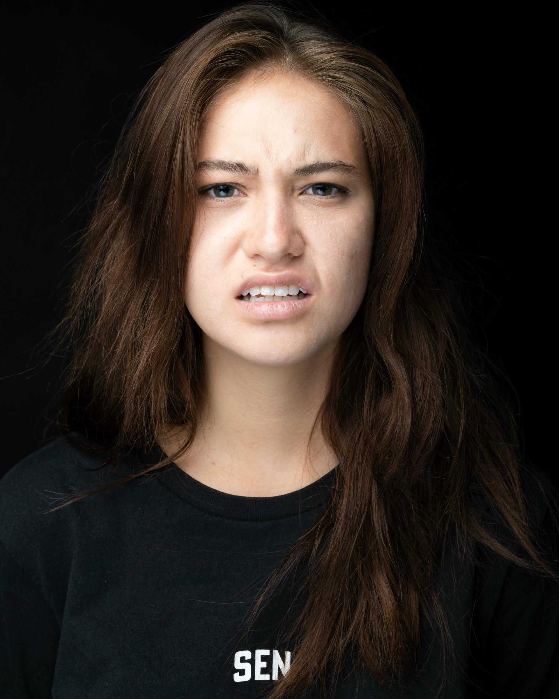 Eine stirnrunzelnde junge Frau | Quelle: Unsplash