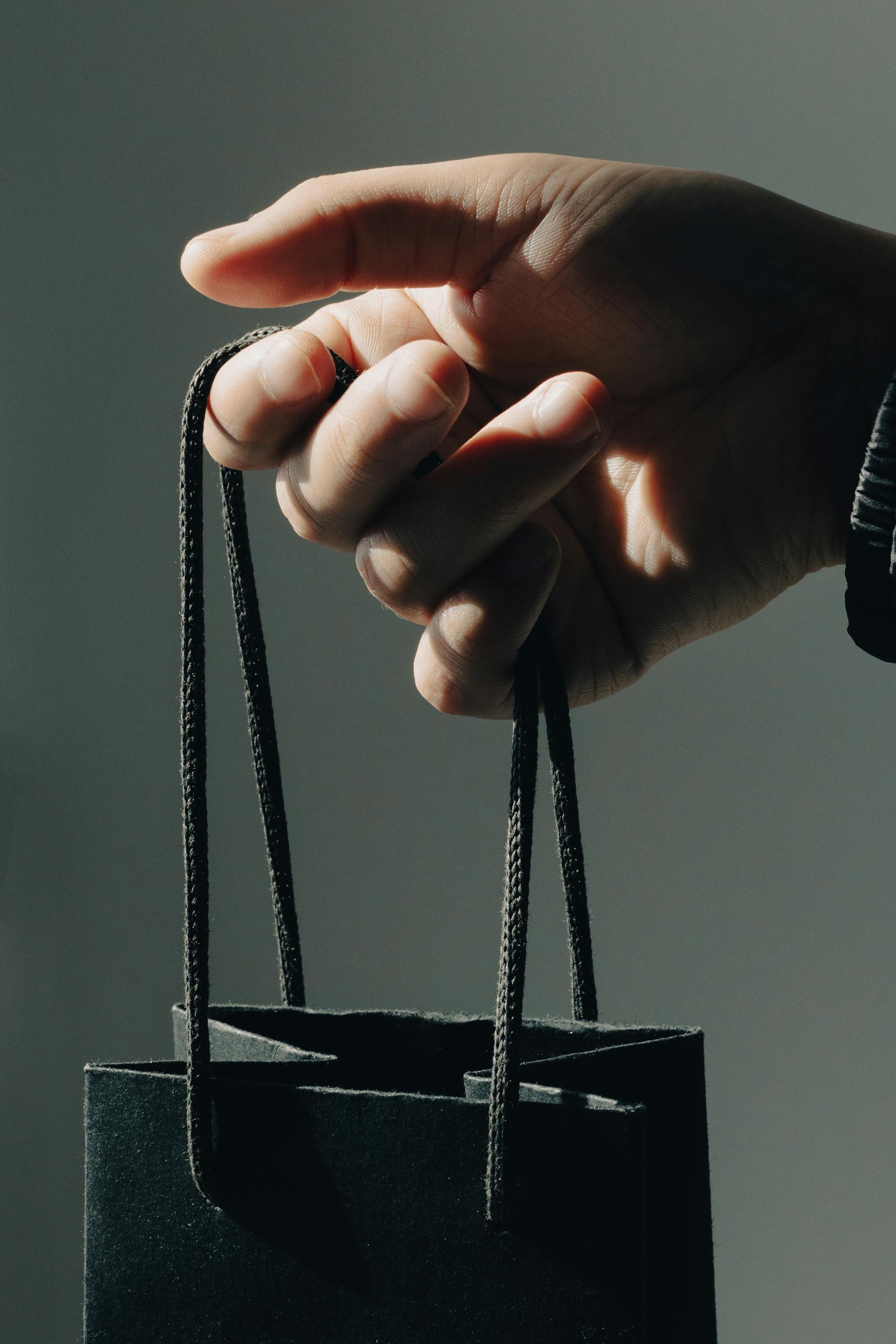 Ein Mann hält eine Geschenktüte | Quelle: Pexels