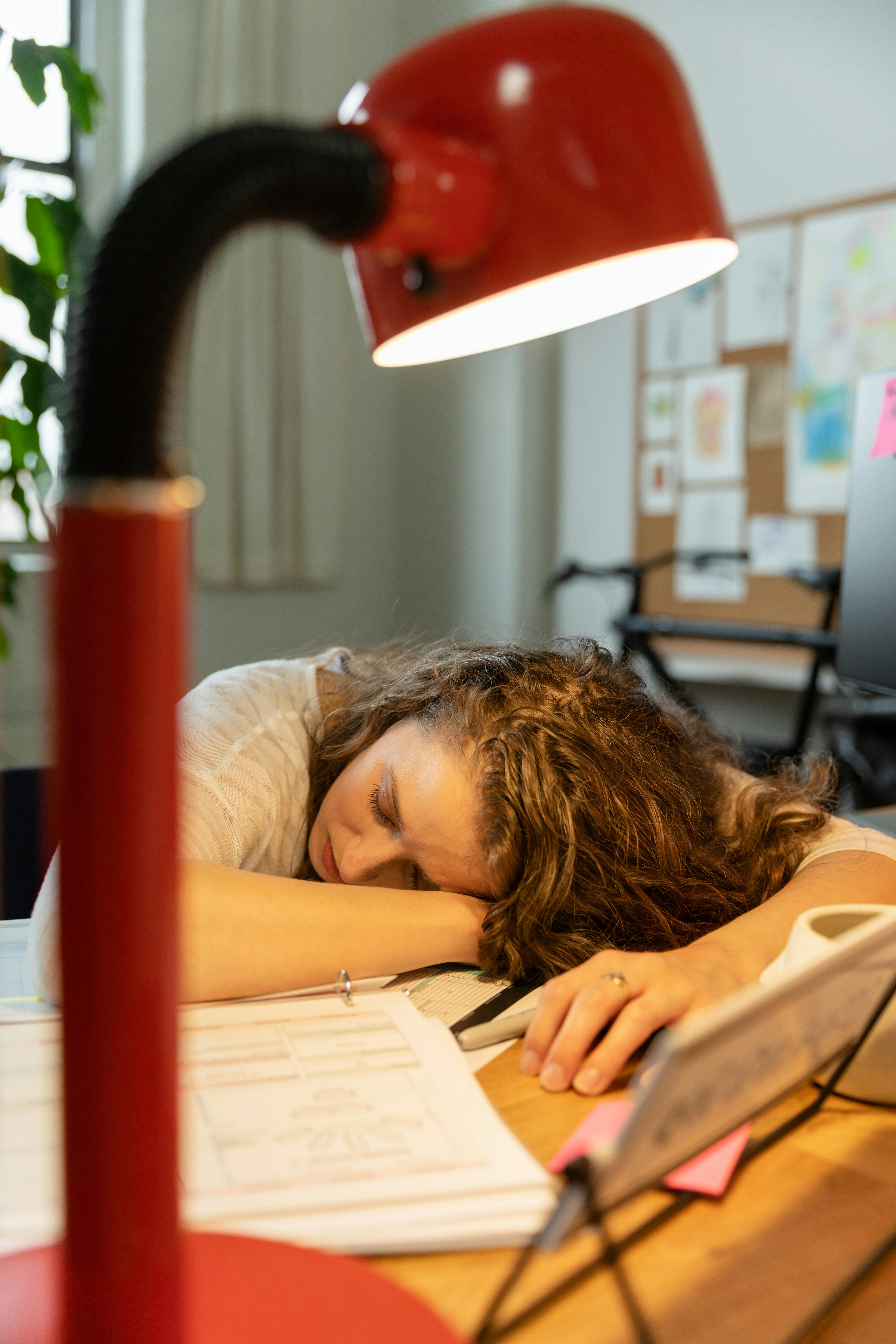 Eine Frau, die auf einem Schreibtisch schläft | Quelle: Pexels
