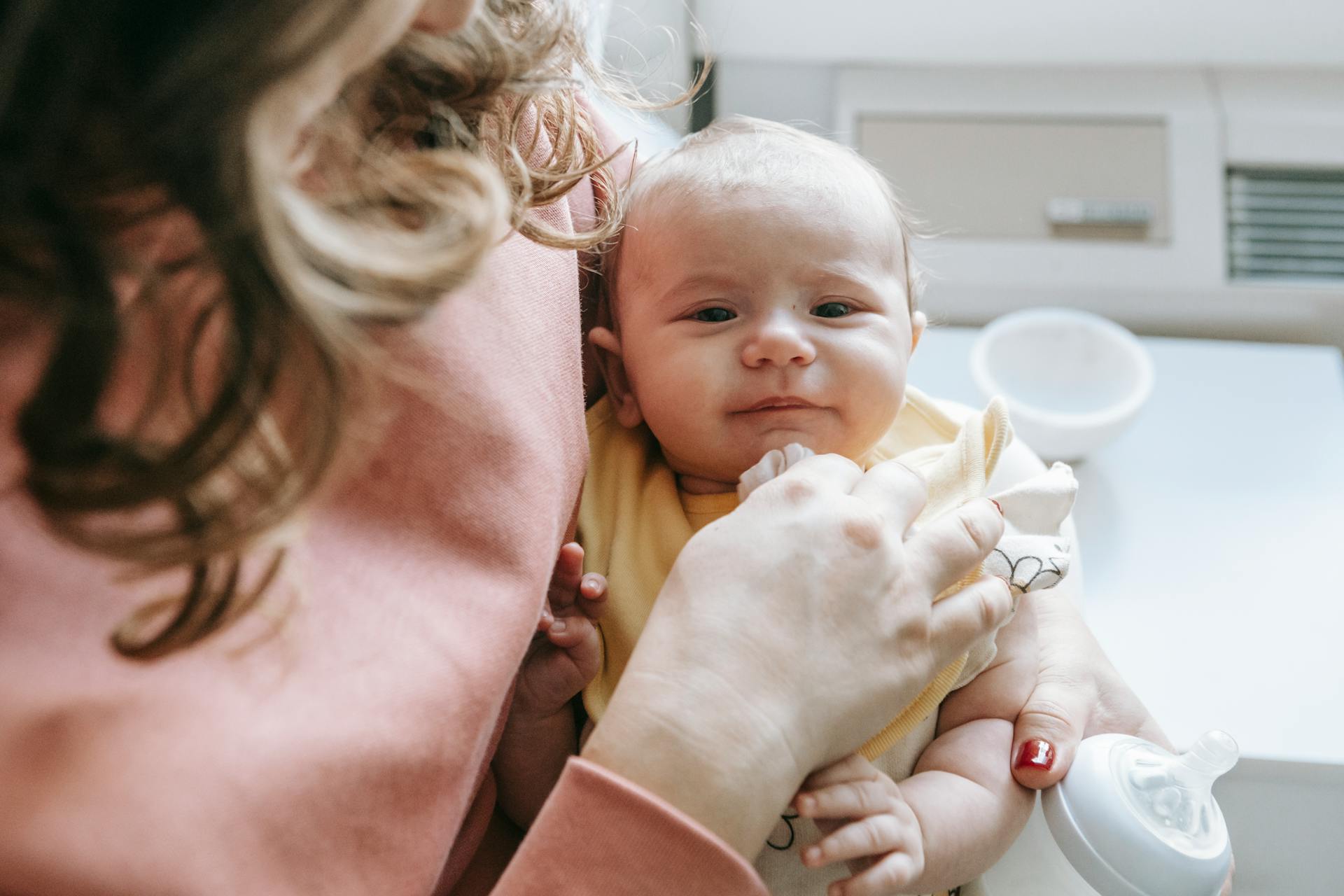 Eine Frau hält ein Baby und eine Saugflasche in der Hand | Quelle: Pexels