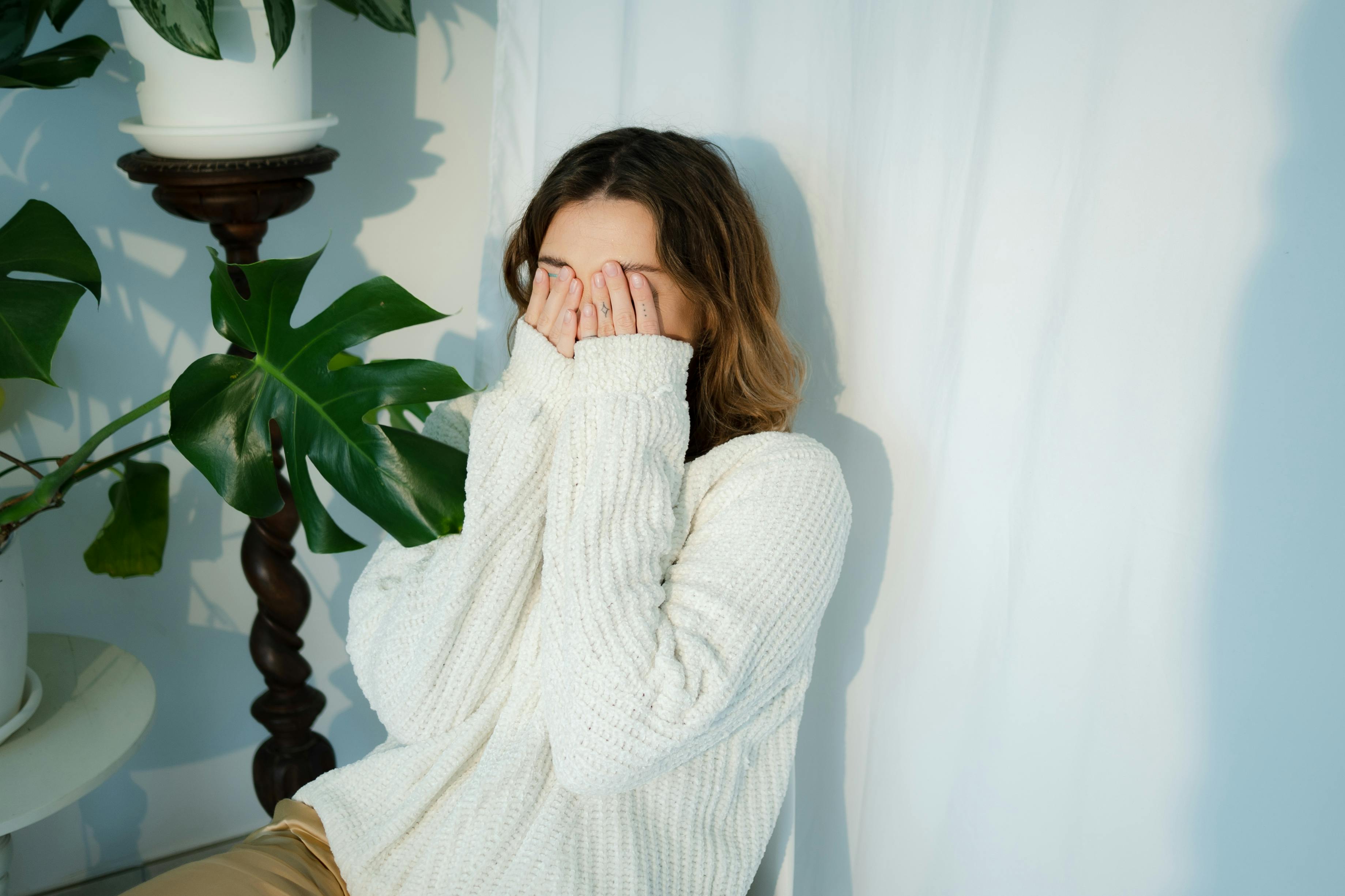 Eine verlegene Frau, die ihr Gesicht bedeckt | Quelle: Pexels