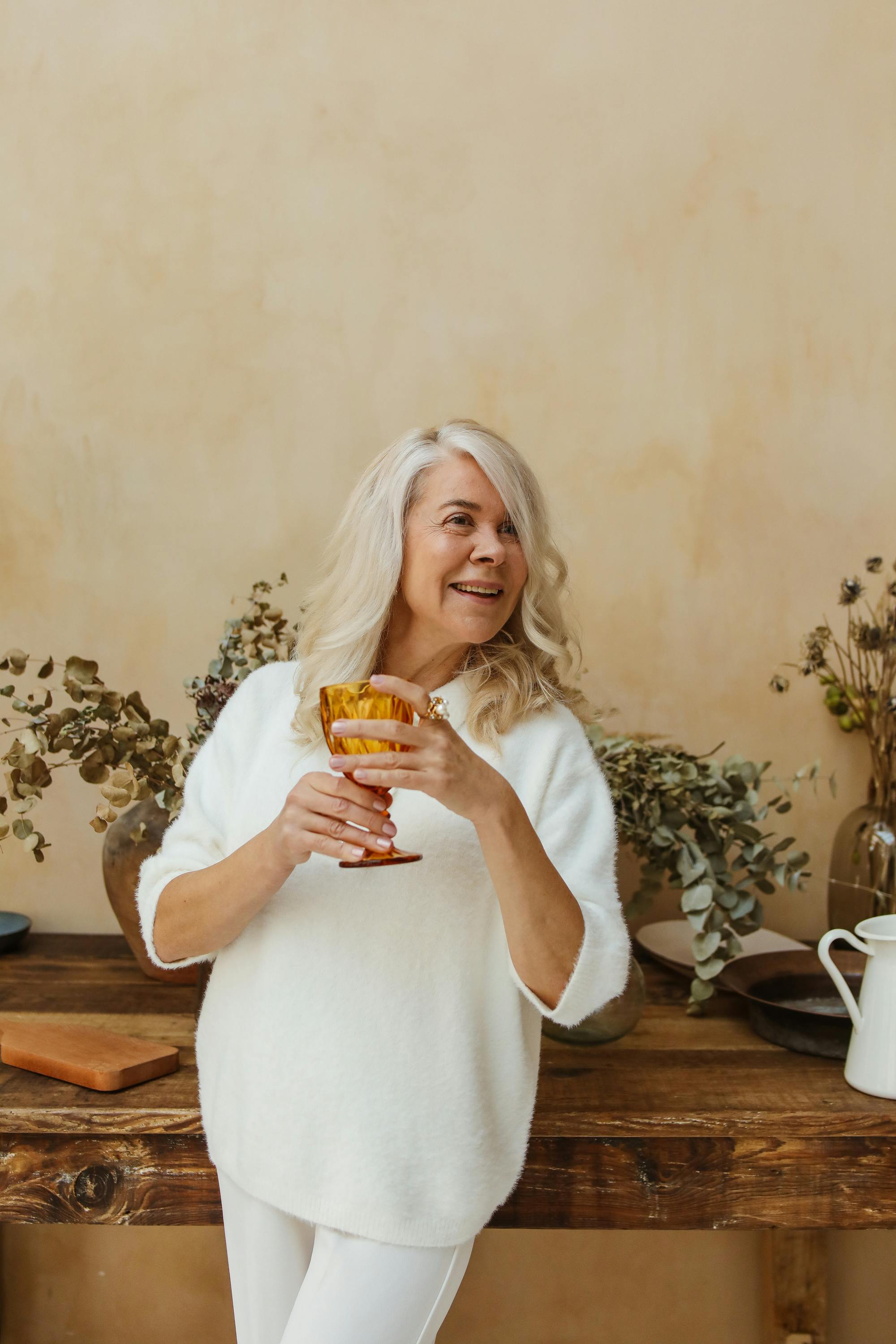 Eine ältere Frau mit einem Glas in der Hand | Quelle: Pexels