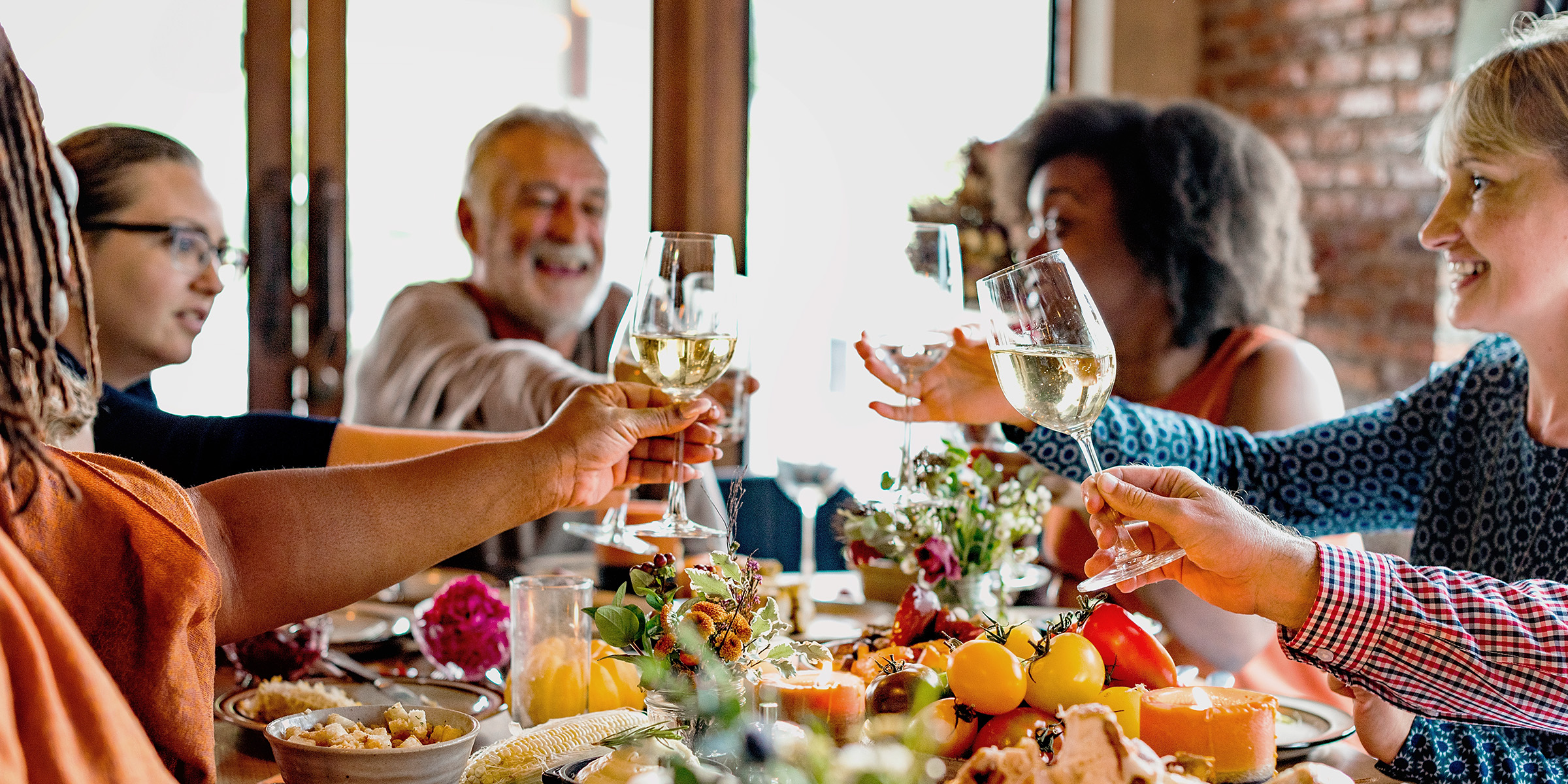 Eine Familie, die beim Abendessen anstößt | Quelle: Shutterstock
