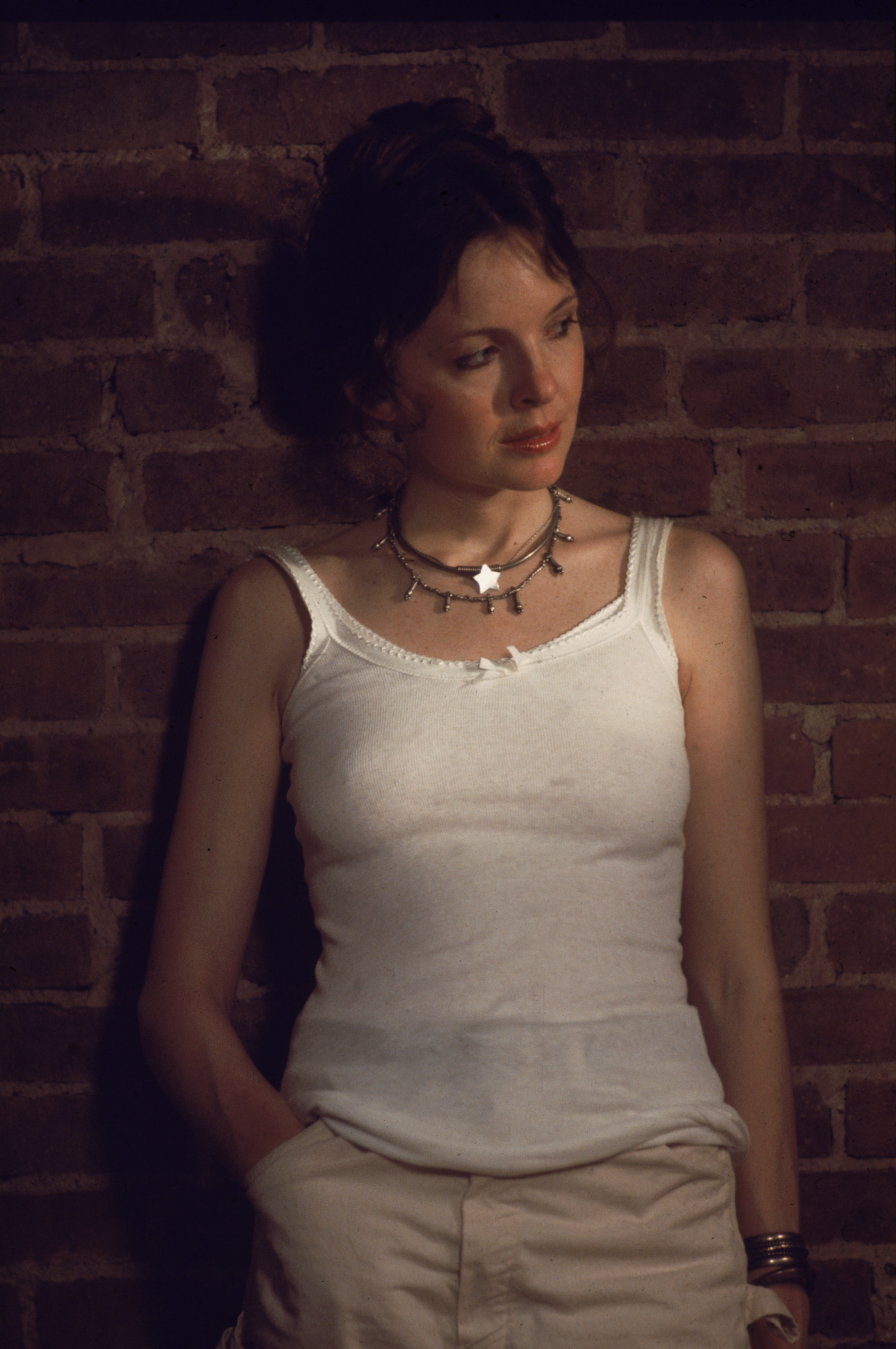 ausDiane Keaton trägt ein weißes Tank-Top und lehnt sich an eine Backsteinmauer | Quelle: GettyImages