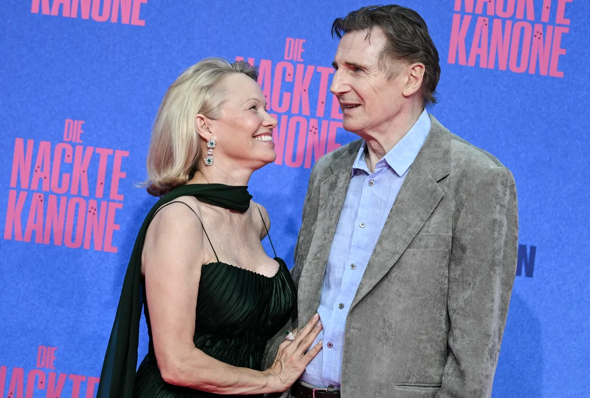 Pamela Anderson blickt Liam Neeson während der deutschen Premiere von „Die nackte Kanone“ am 24. Juli 2025 in Berlin liebevoll an.