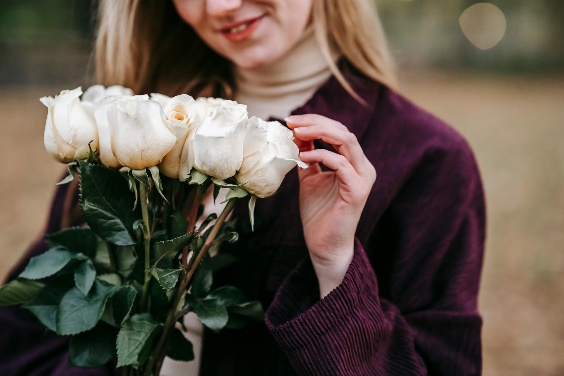 Eine erfreute Frau mit Rosen in der Hand | Quelle: Pexels