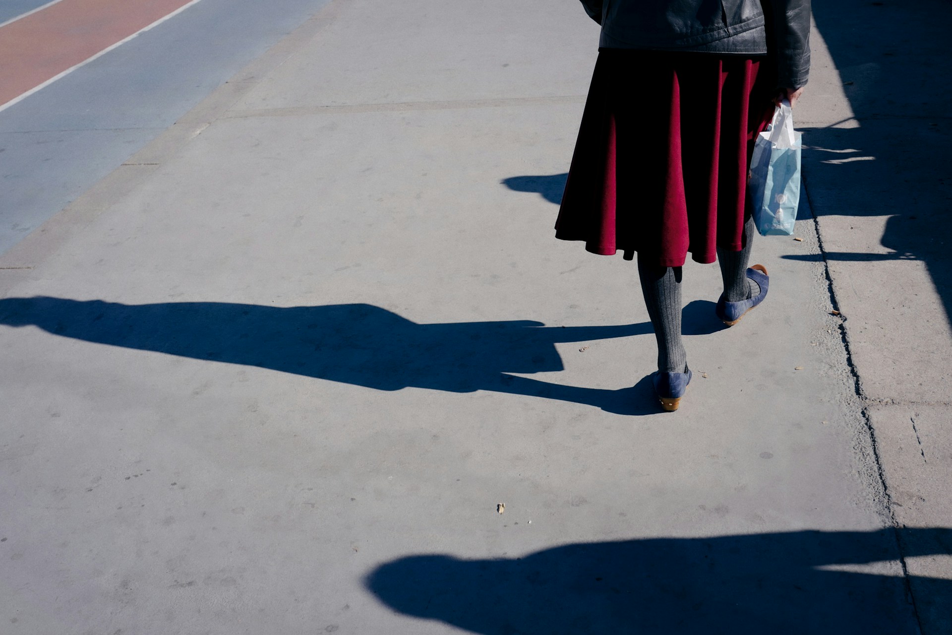 Eine Frau, die eine Tasche trägt und auf der Straße geht | Quelle: Unsplash