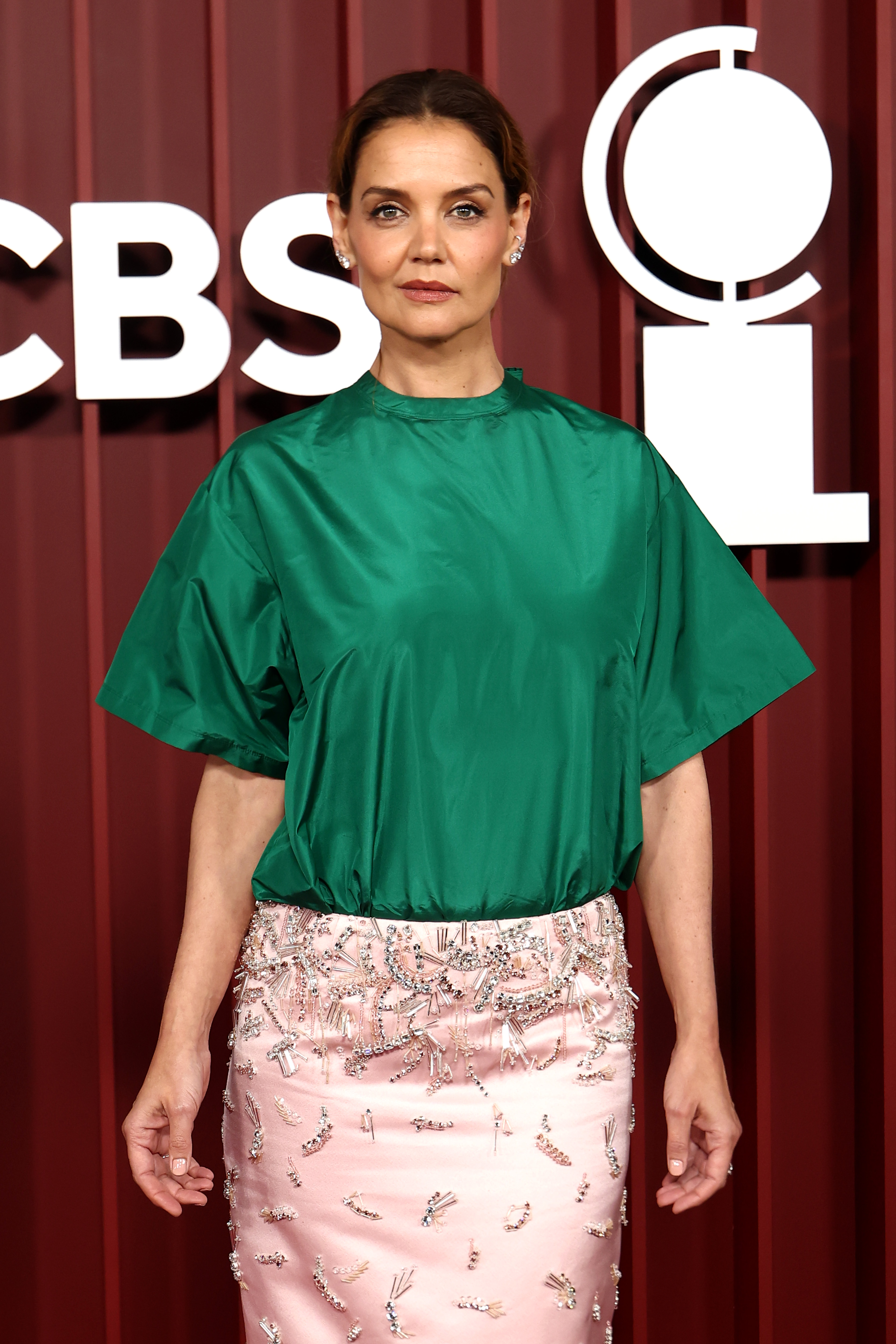 Katie Holmes posiert bei den 78. Tony Awards in einem strukturierten grünen Satintop und einem blassrosa Rock mit Kristallstickerei. Ihr selbstbewusster Gesichtsausdruck unterstreicht die Eleganz dieser gewagten Farbkombination in der Radio City Music Hall.