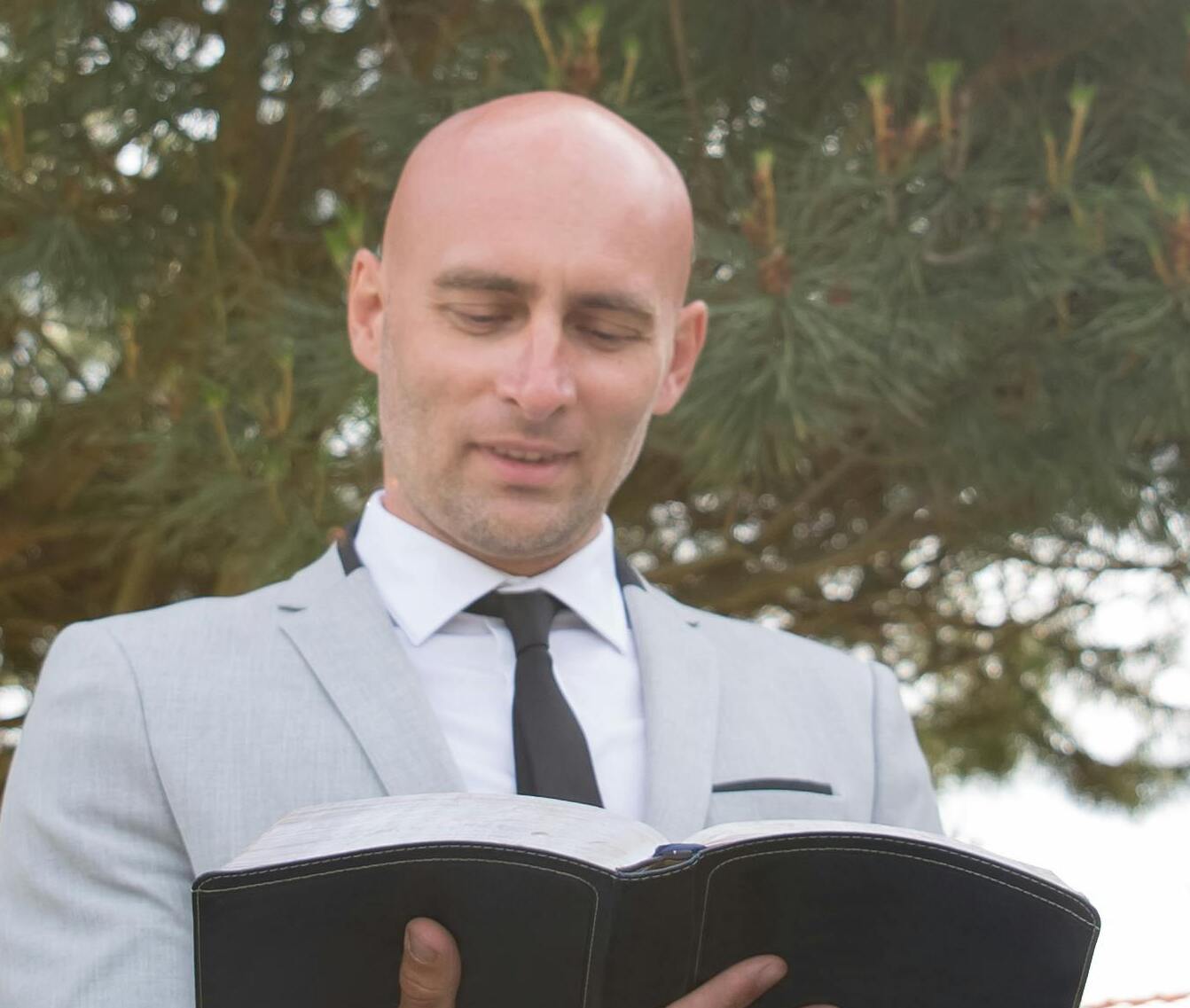 Ein Mann, der als Trauredner fungiert und ein Buch liest | Quelle: Pexels