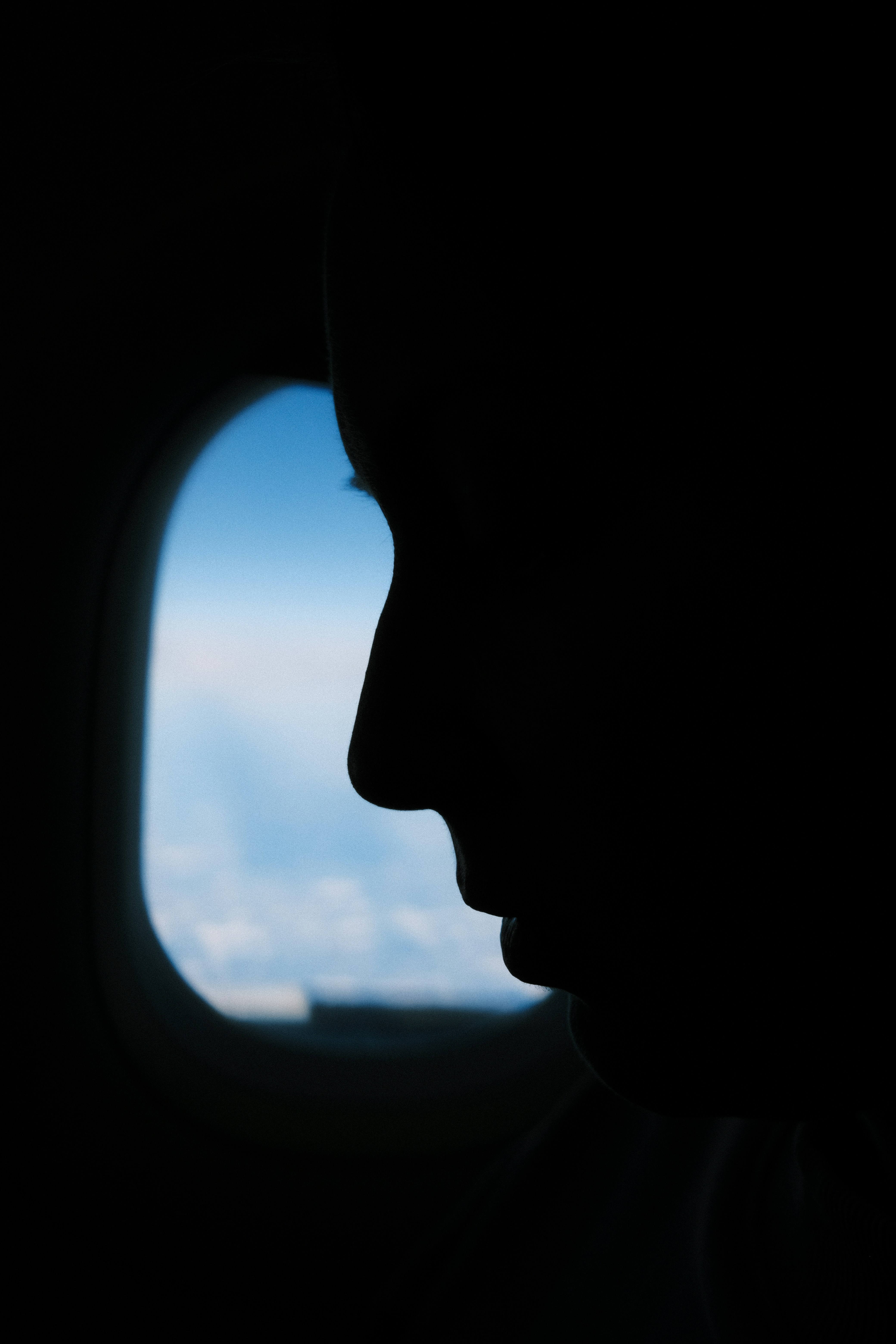 Eine Silhouette einer Person, die in einem Flugzeug sitzt | Quelle: Unsplash