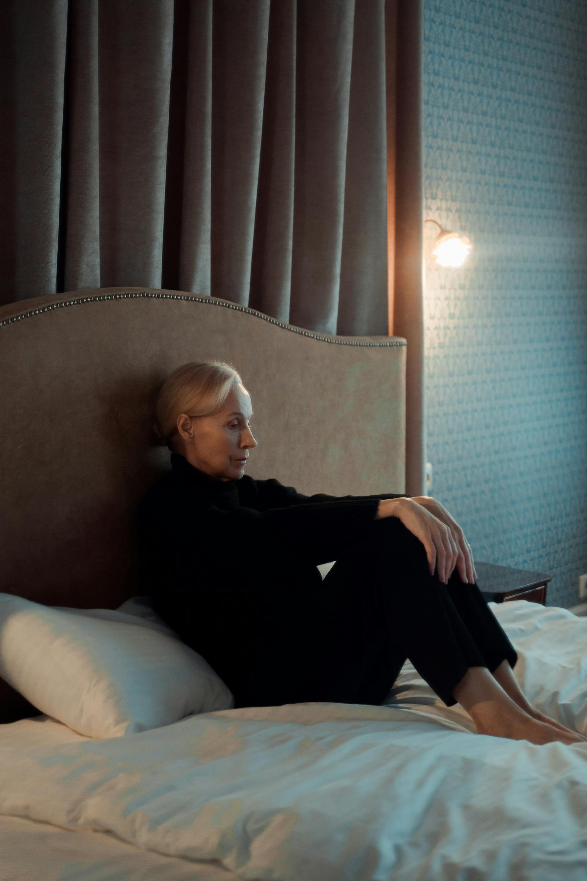 Eine Frau, die auf ihrem Bett sitzt | Quelle: Pexels