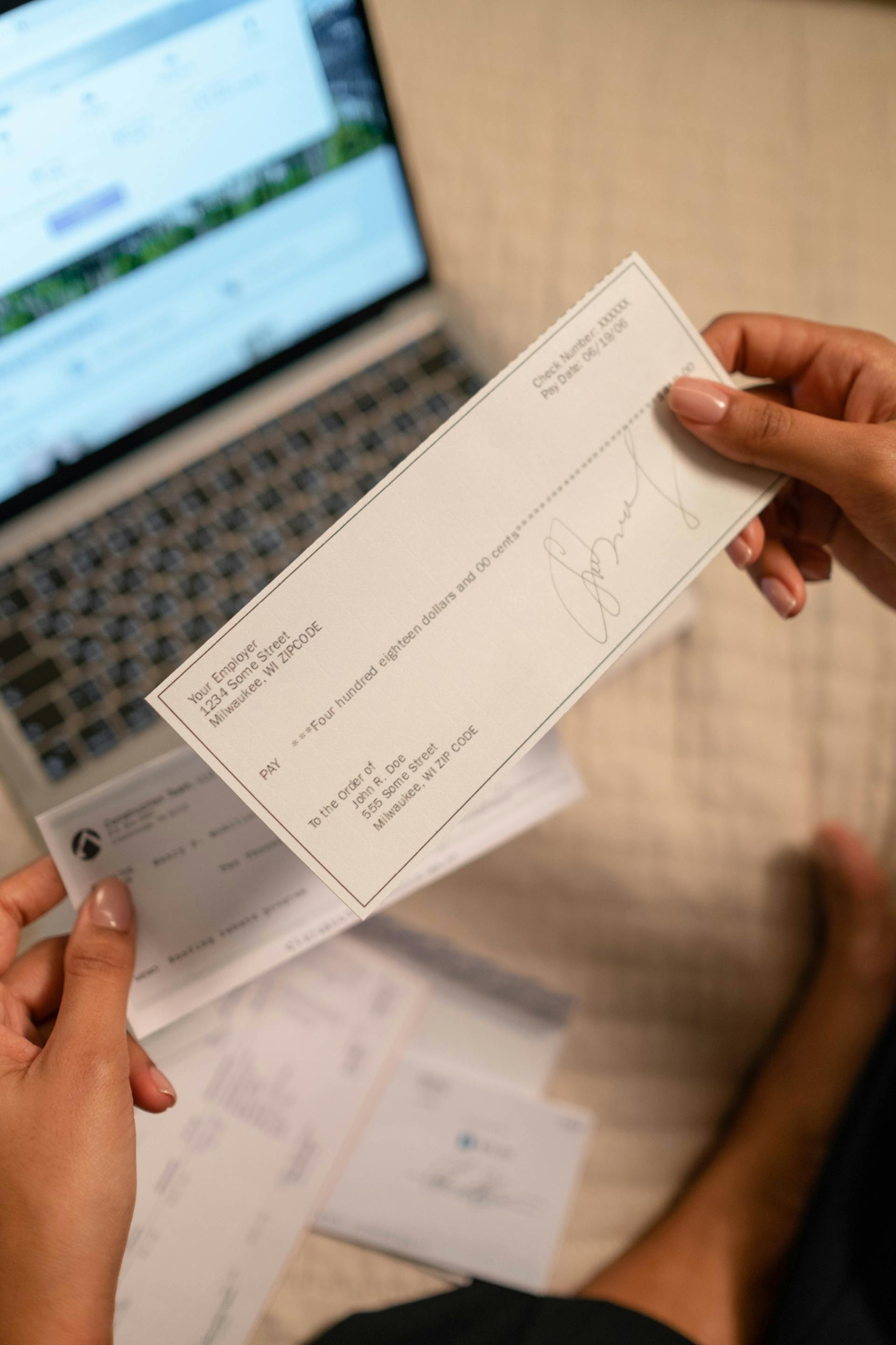 Eine Person hält einen Bankscheck | Quelle: Pexels