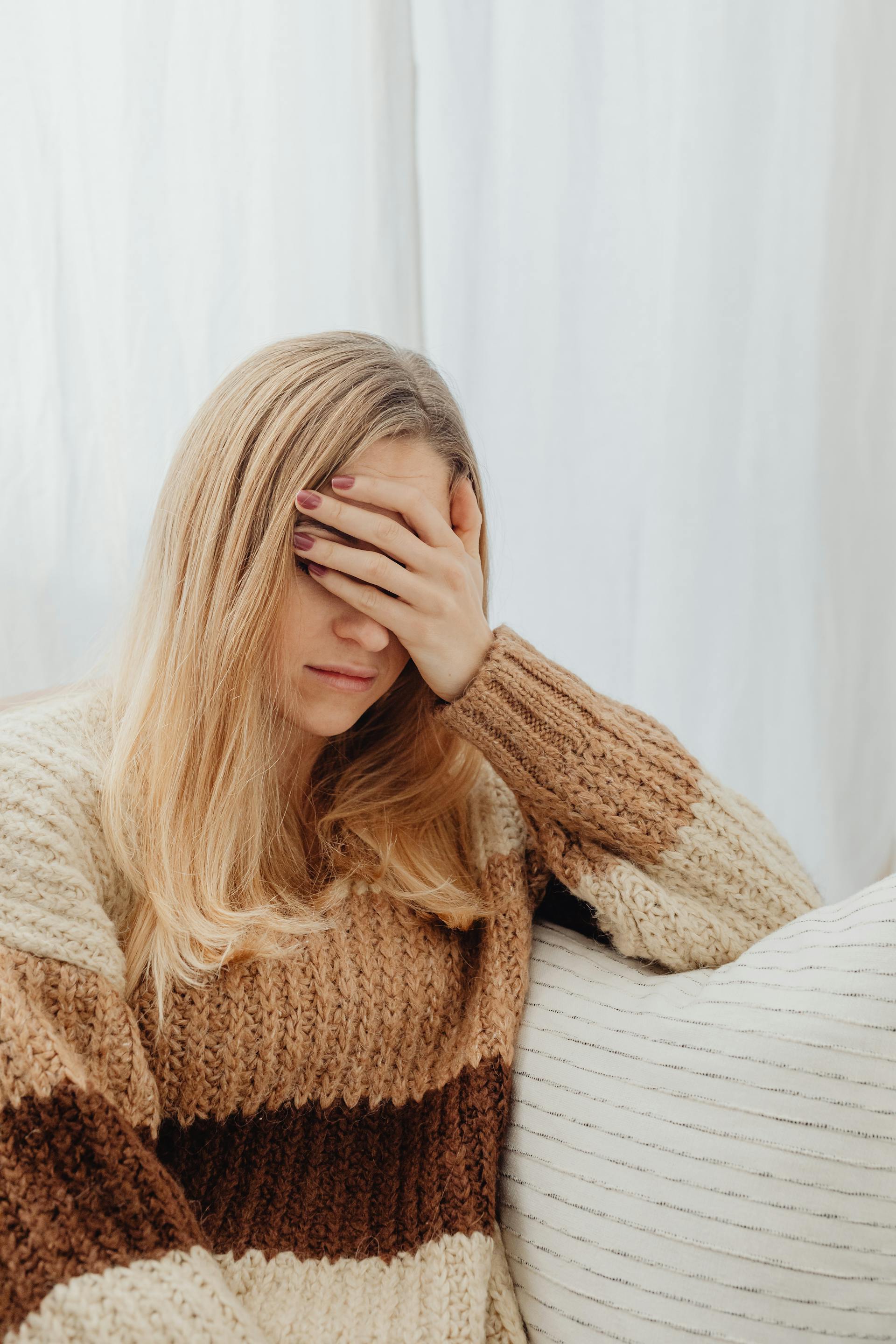 Eine verzweifelte Frau mit einer Hand auf ihrer Stirn | Quelle: Pexels