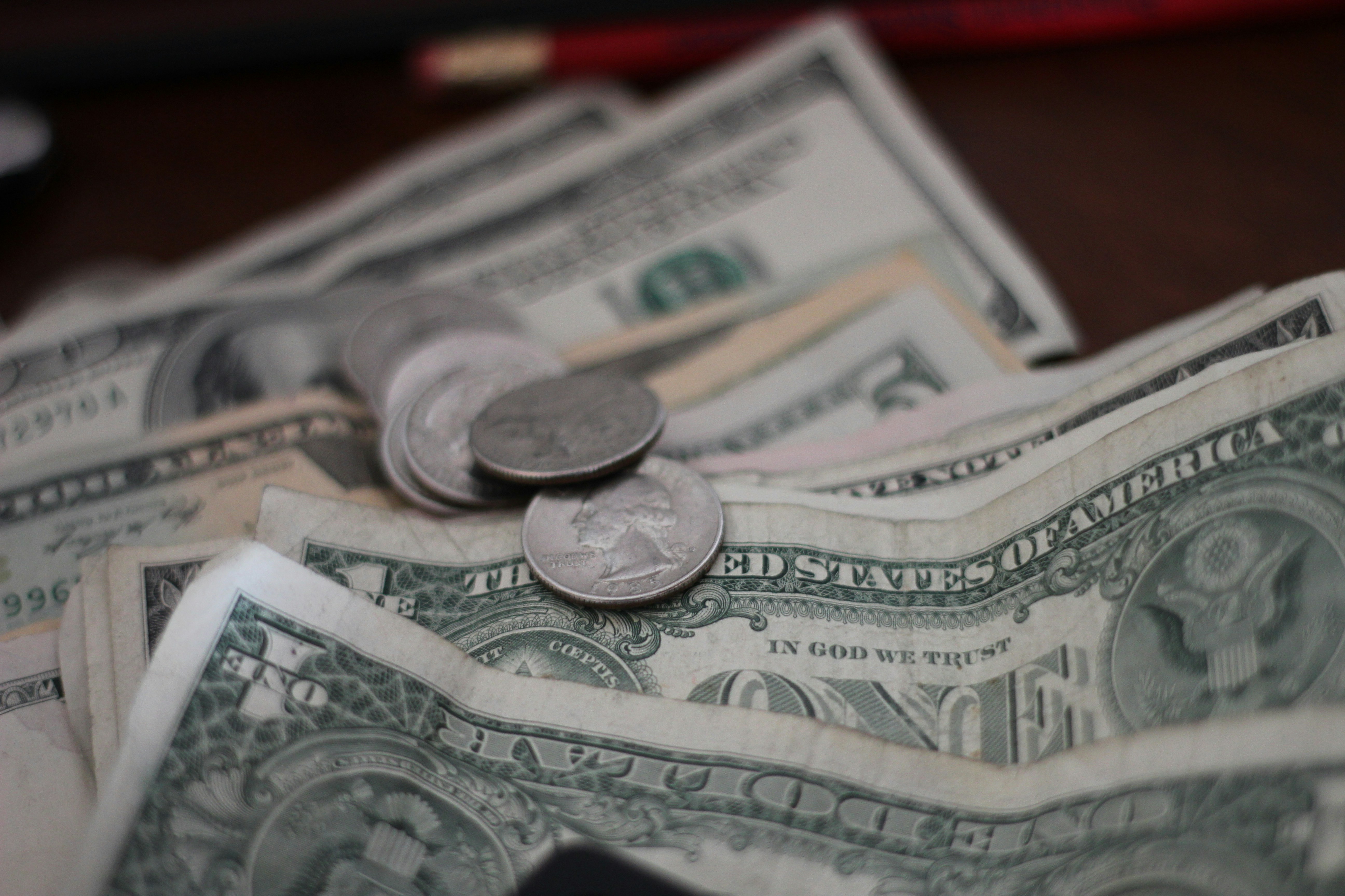 Eine Nahaufnahme von Dollars und Münzen | Quelle: Unsplash