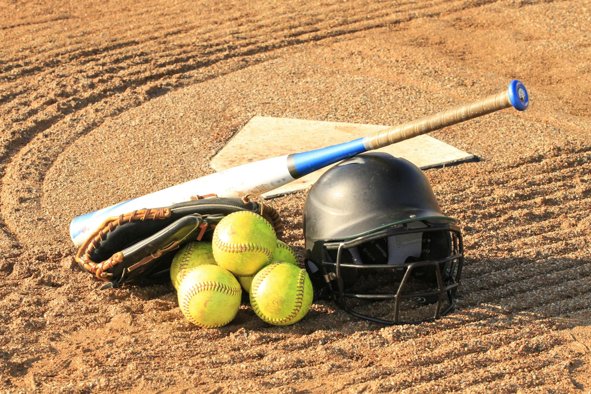 Ein Baseballschläger mit einem Helm und Bällen | Quelle: Pexels