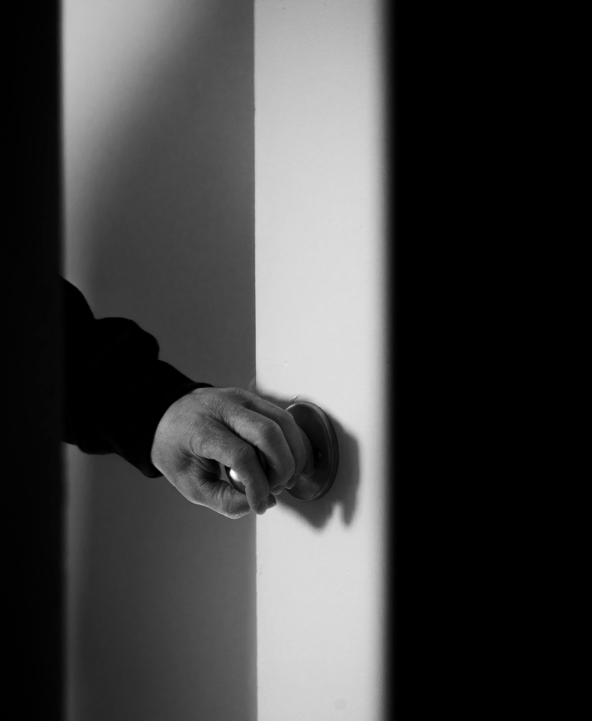 Die Hand eines Mannes an einer Türklinke | Quelle: Pexels