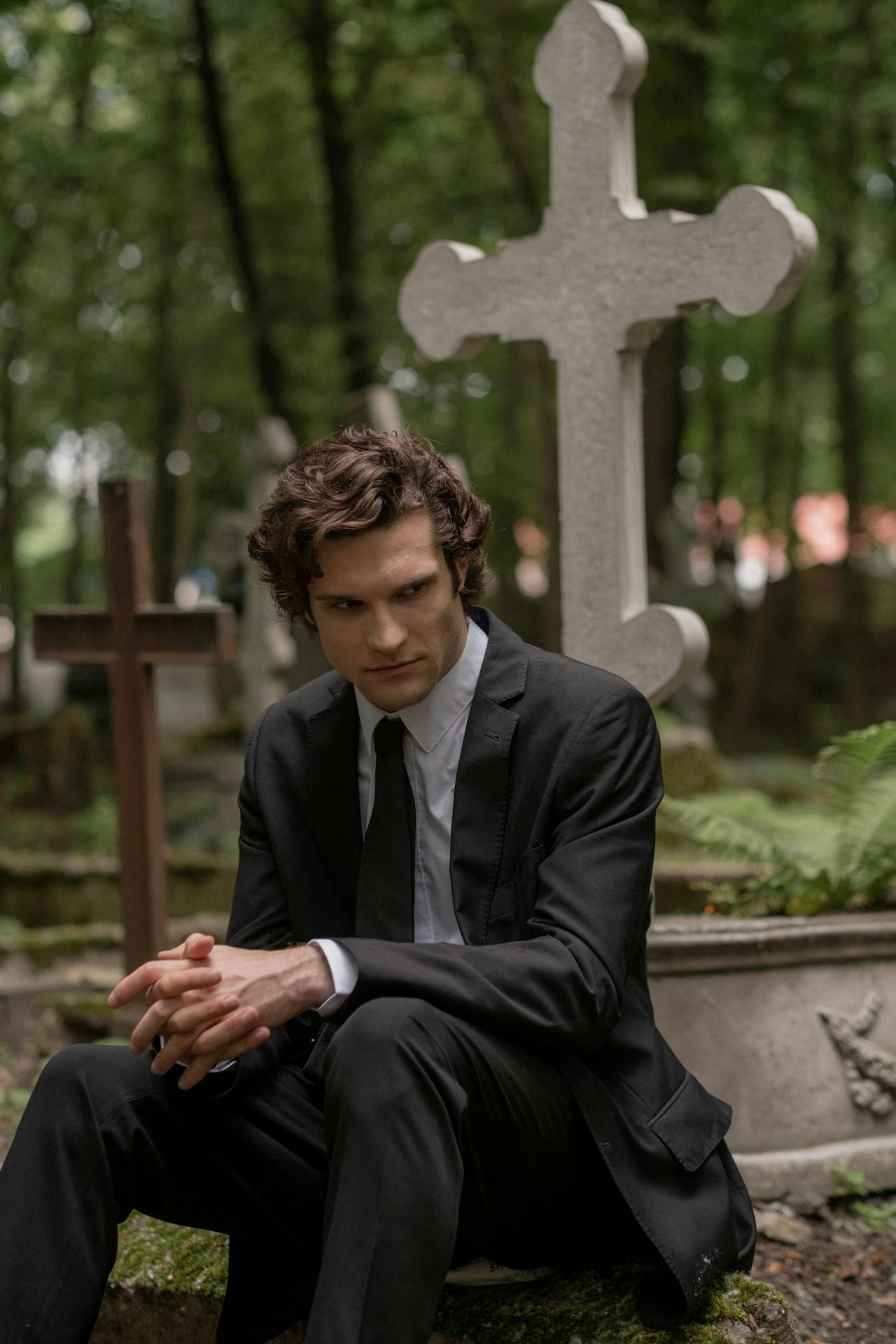 Ein Mann sitzt auf einem Friedhof | Quelle: Pexels