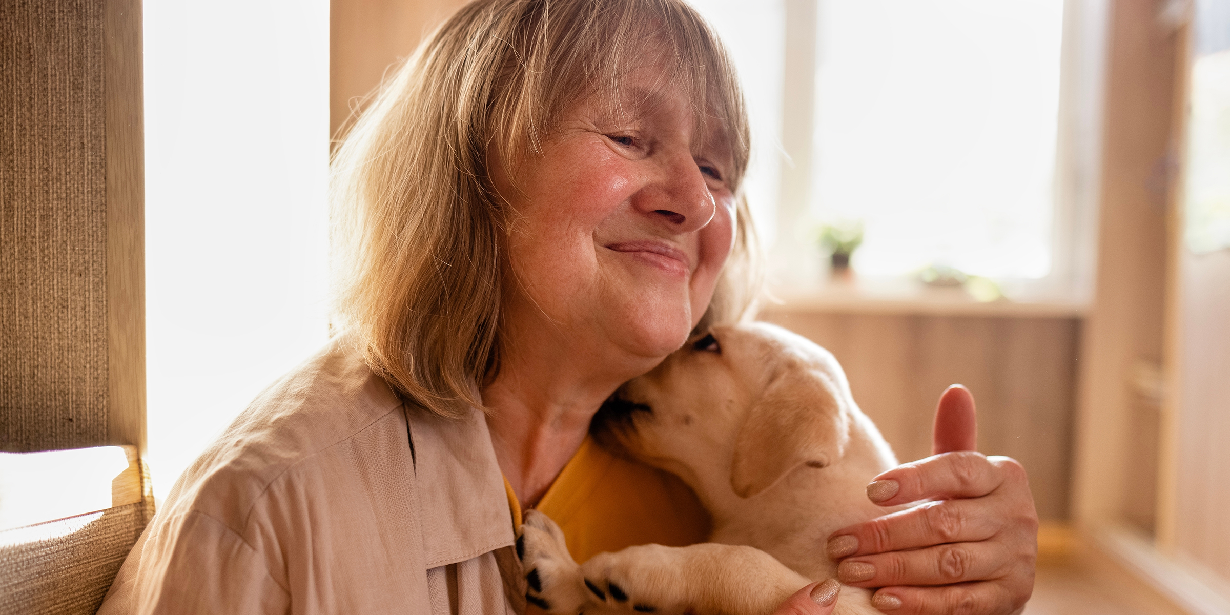 Eine reife Frau kuschelt mit einem Hund | Quelle: Shutterstock