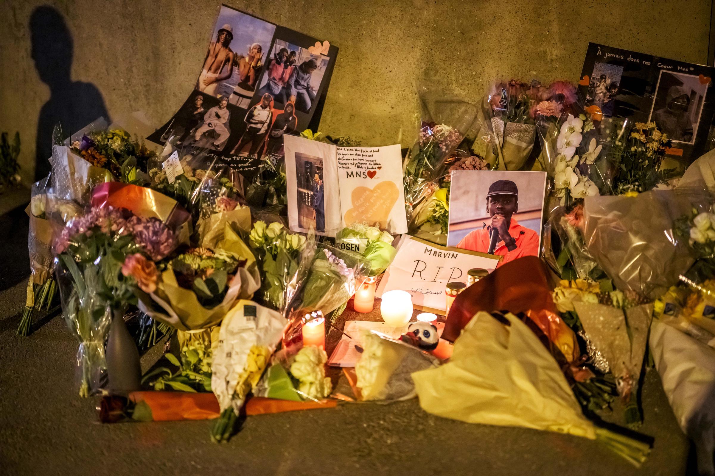 Blumen, Kerzen und Fotos lagen an der Stelle, an der der Teenager Mavin ums Leben kam, als er mit einem gestohlenen Motorroller vor der örtlichen Polizei flüchtete. Die Proteste in dem Viertel in Lausanne dauerten am späten Abend des 25. August 2025 bereits den zweiten Tag an. | Quelle: Getty Images
