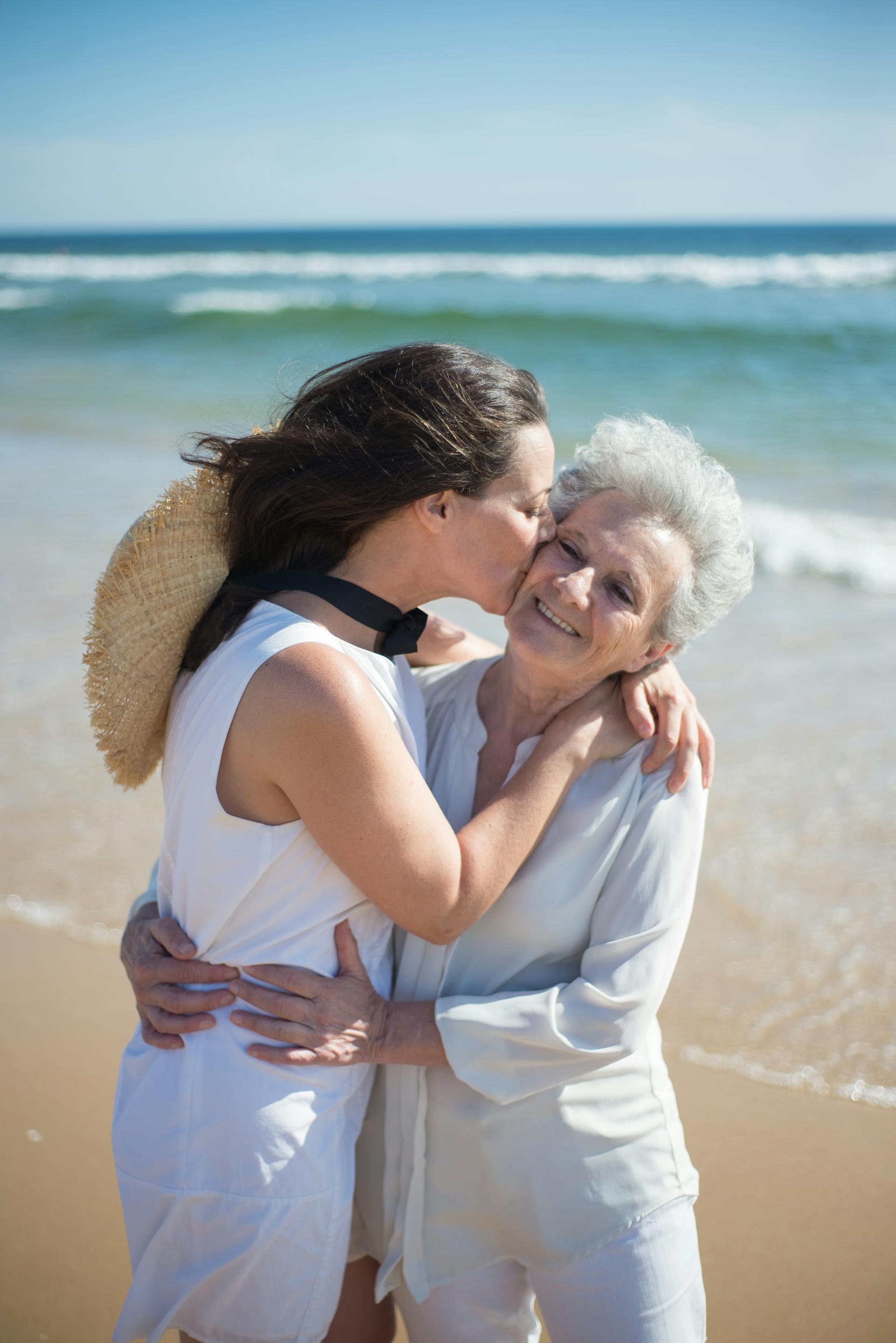 Eine Frau, die ihre Mutter küsst, während sie am Strand steht | Quelle: Pexels