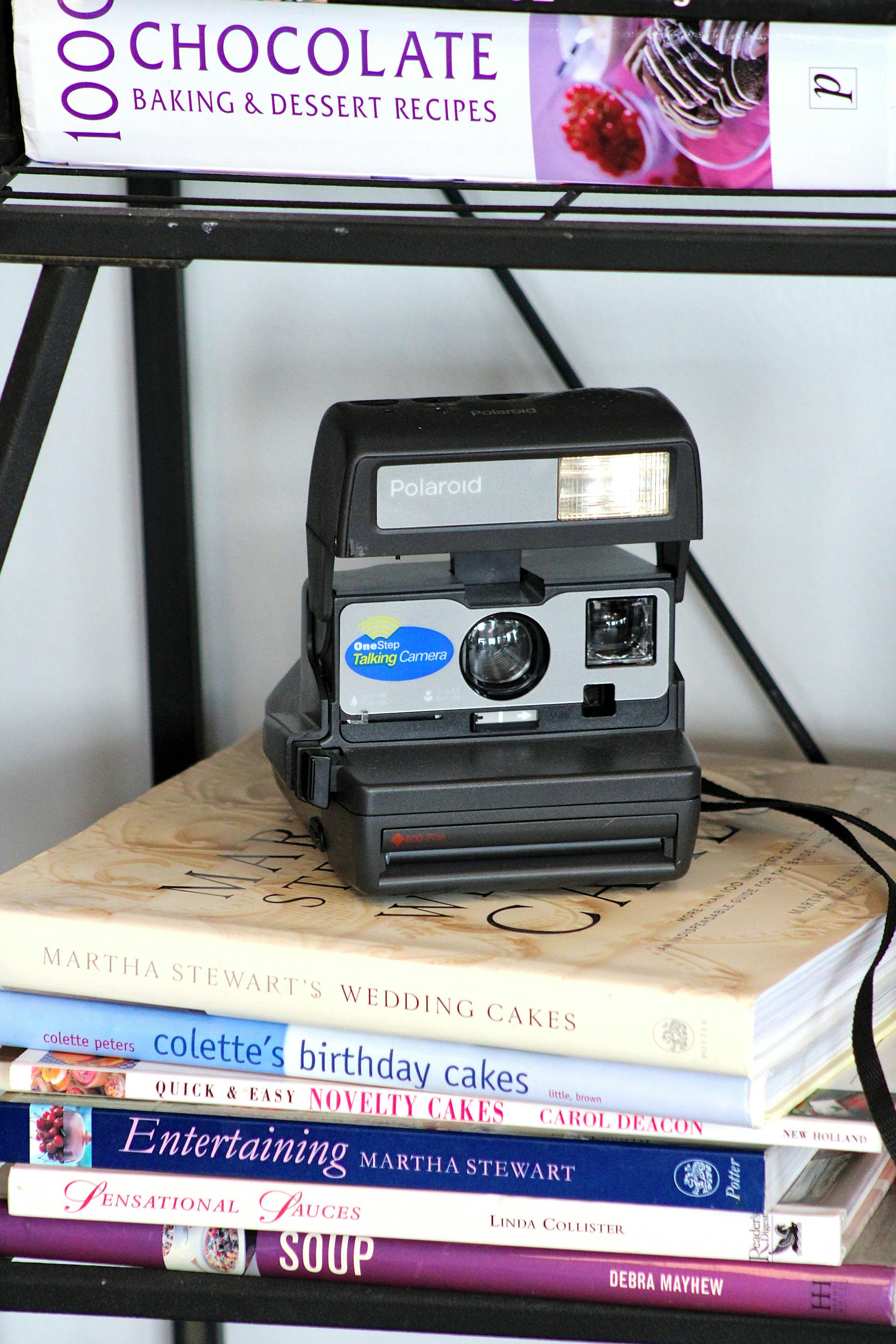 Eine alte Polaroidkamera, die auf Kochbüchern liegt | Quelle: Pexels