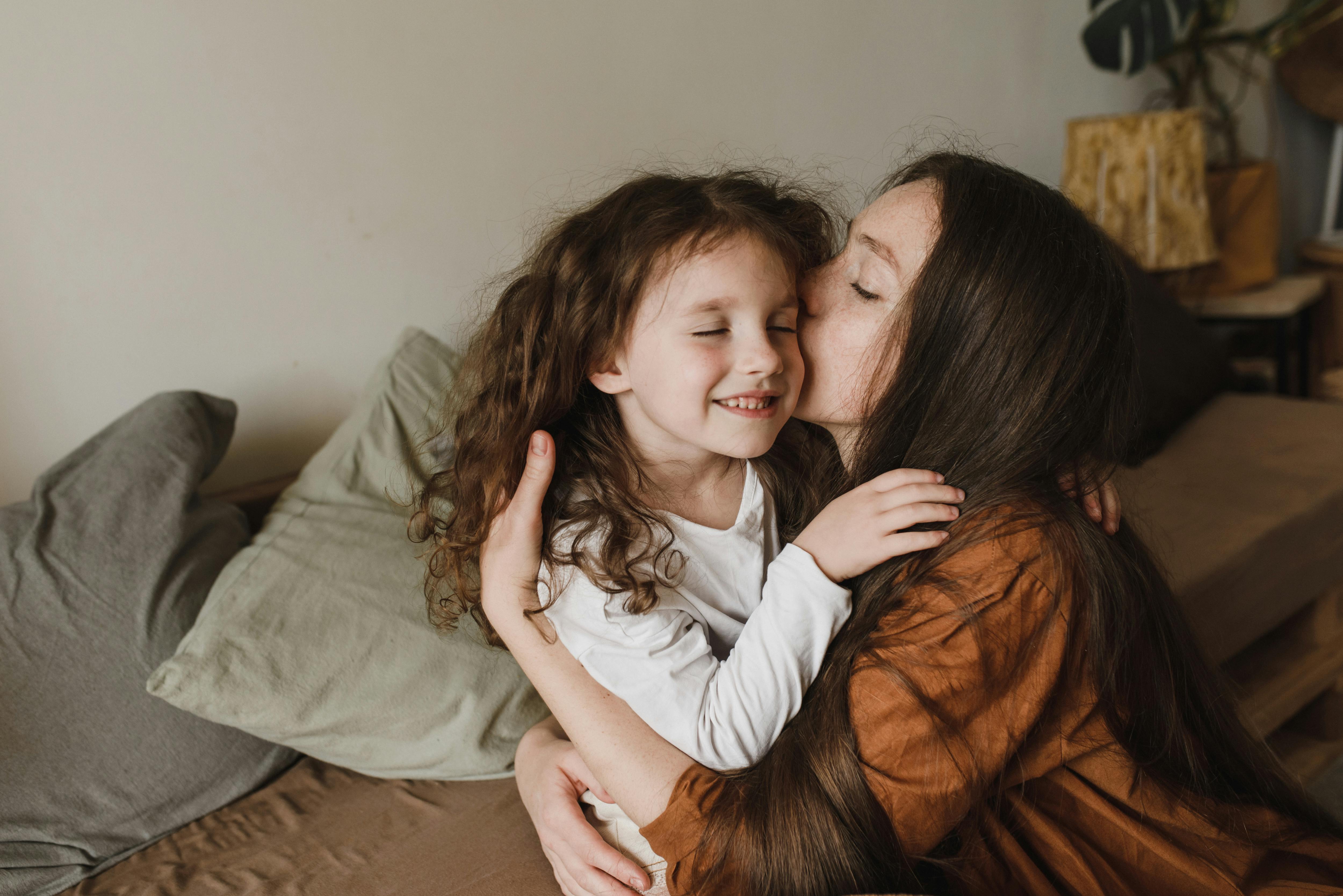 Eine Mutter kuschelt mit ihrer Tochter | Quelle: Pexels